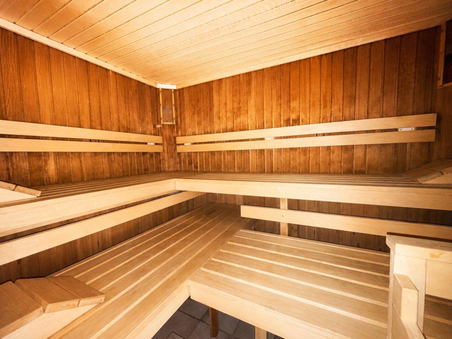 Traditionelle Holzsauna mit mehreren Sitzebenen für Entspannung und Wellness.