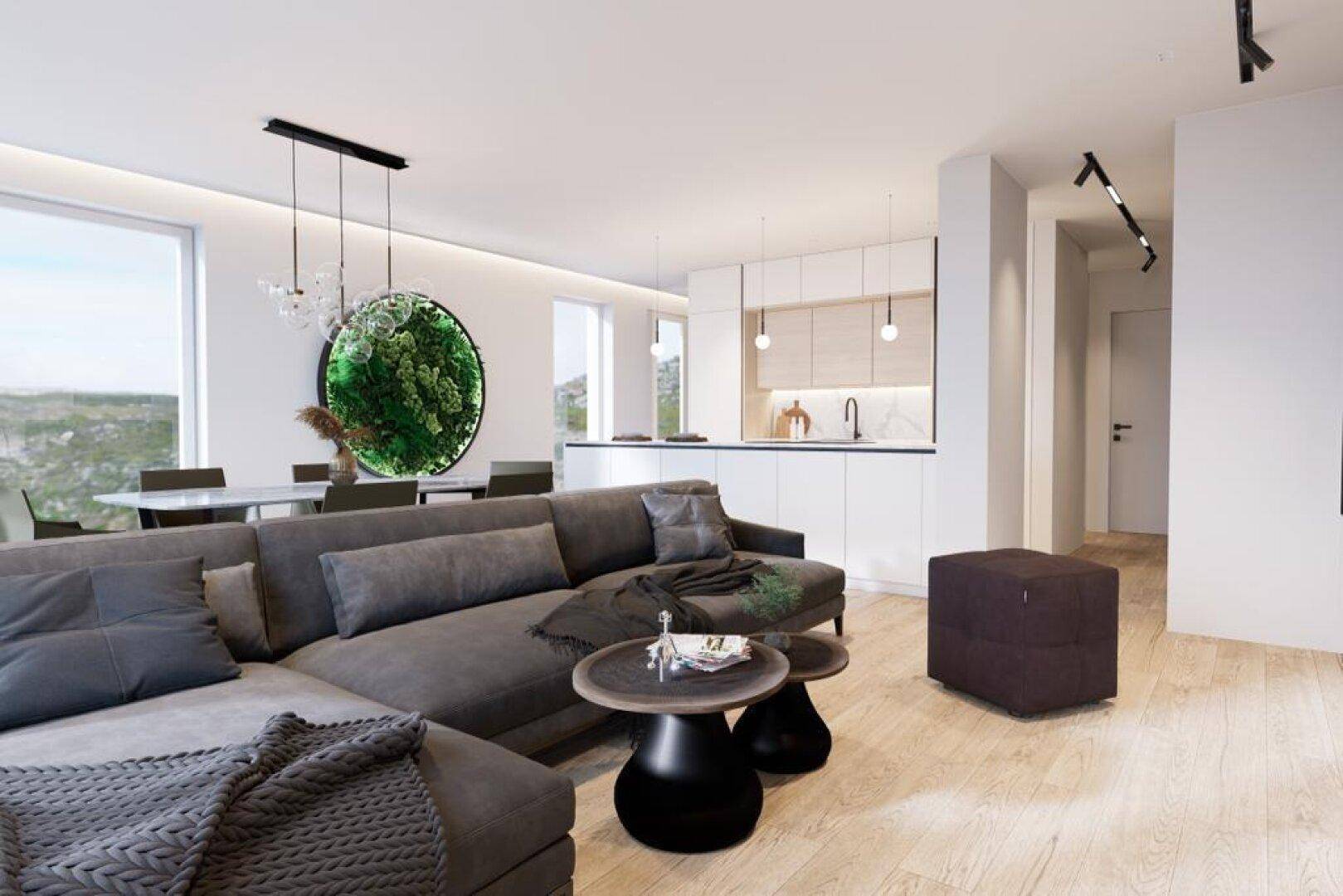 Heller Wohnbereich mit großem Sofa, Blick auf die offene Küche und Essbereich.