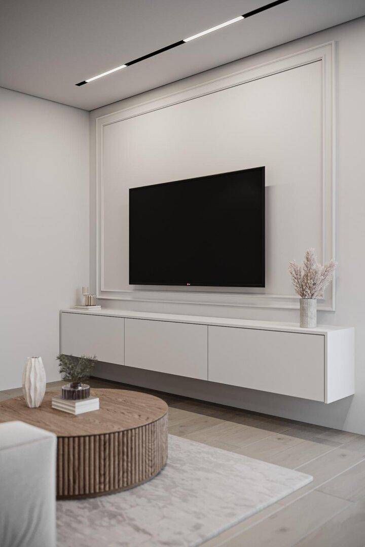 Modernes Wohnzimmer mit wandmontiertem Fernseher, schwebendem Sideboard und Holztisch.