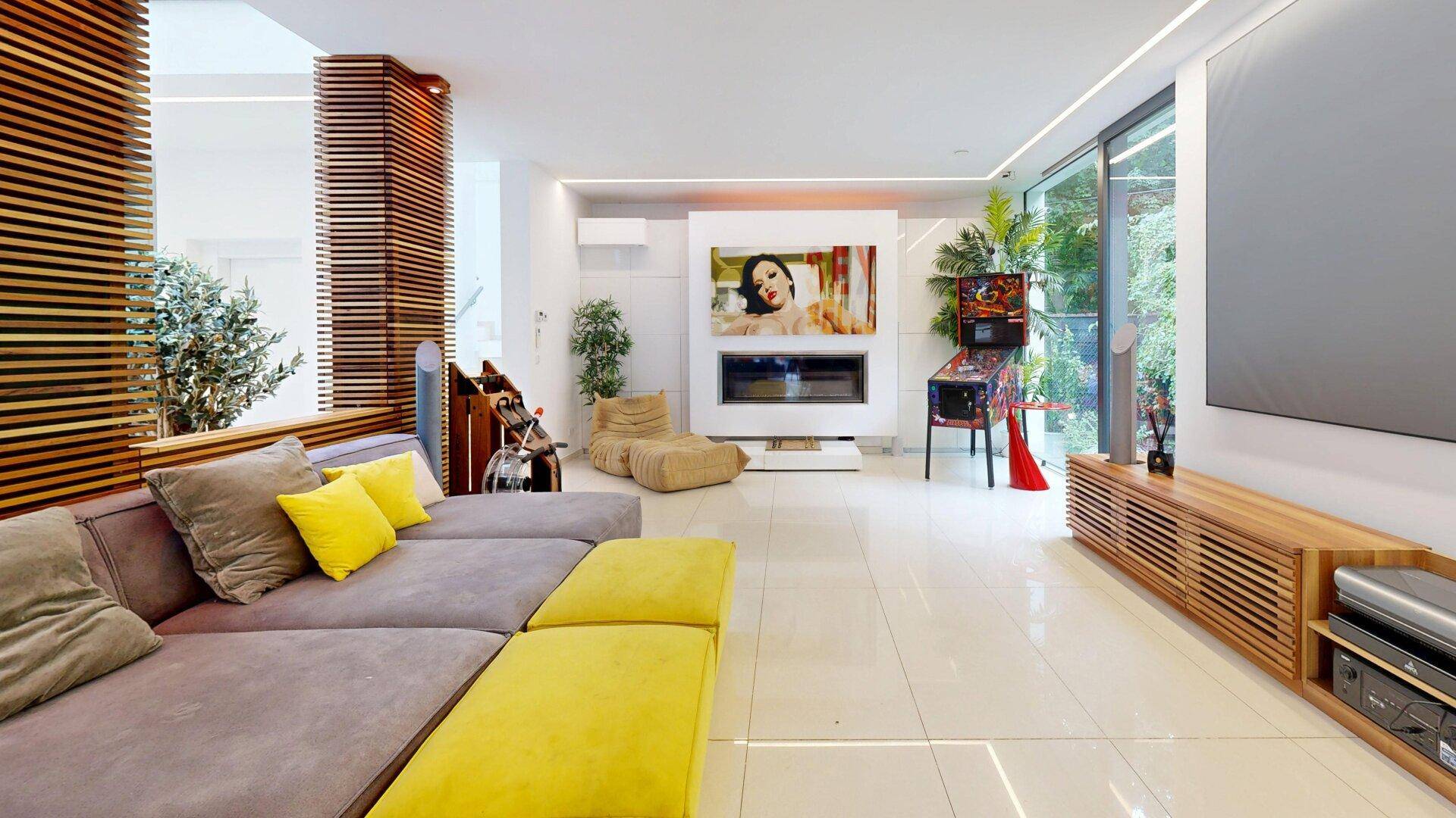 Modernes Wohnzimmer mit großem Sofa, Kamin und Unterhaltungssystem.
