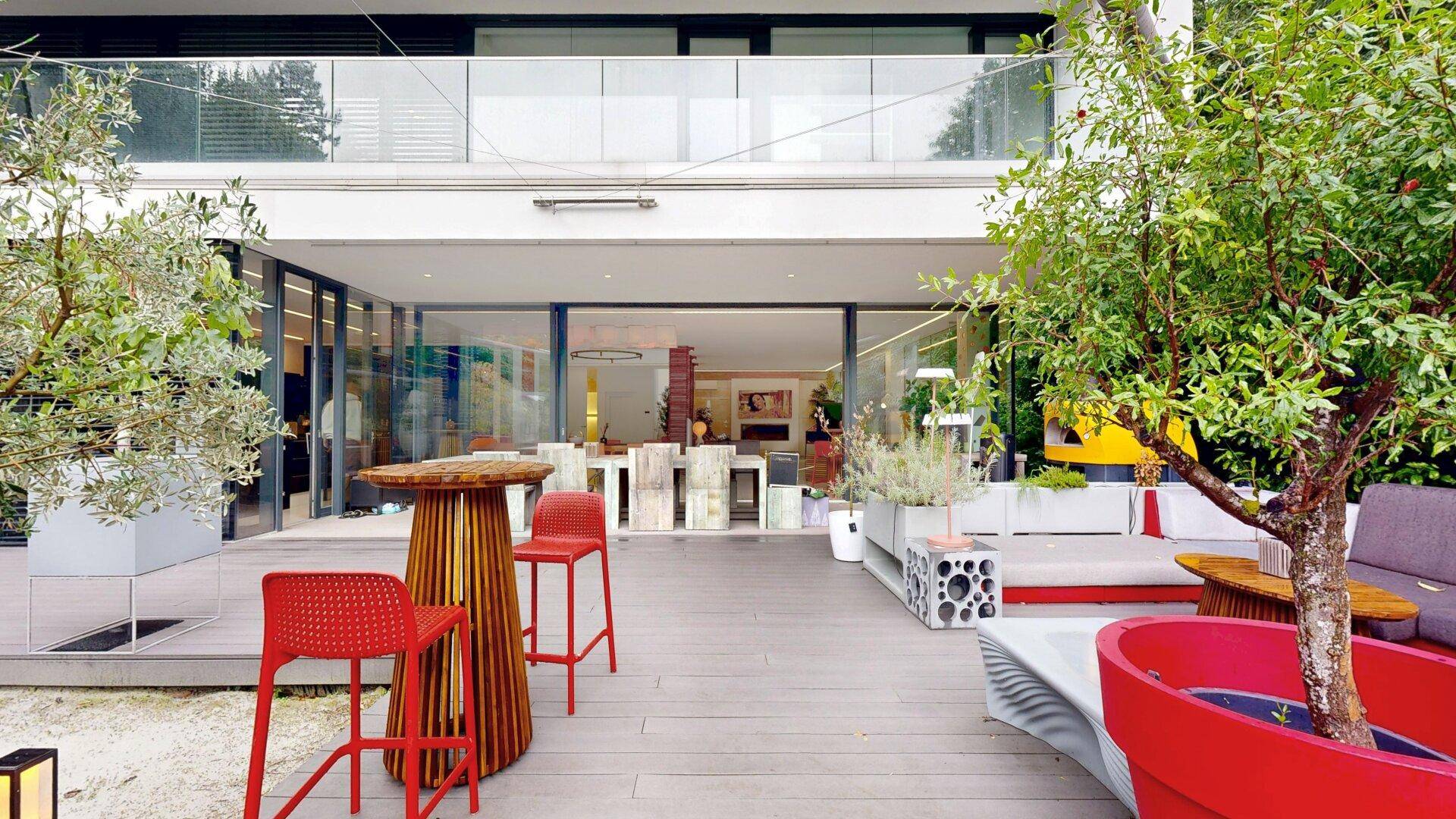 Moderne Terrasse mit Sitzgelegenheiten und Blick auf den offenen Wohnbereich des Hauses.