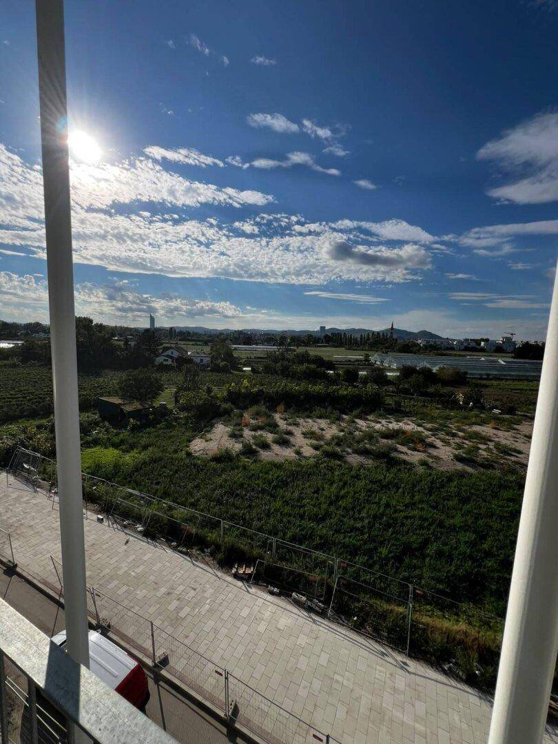 Panoramablick von der Immobilie auf eine weite grüne Landschaft und die Skyline in der Ferne.