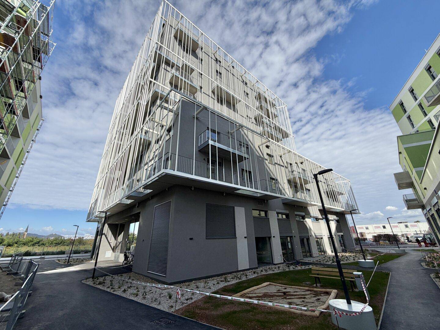 Modernes Apartmentgebäude mit auffälliger weißer Gitterfassade und zeitgenössischer Architektur.