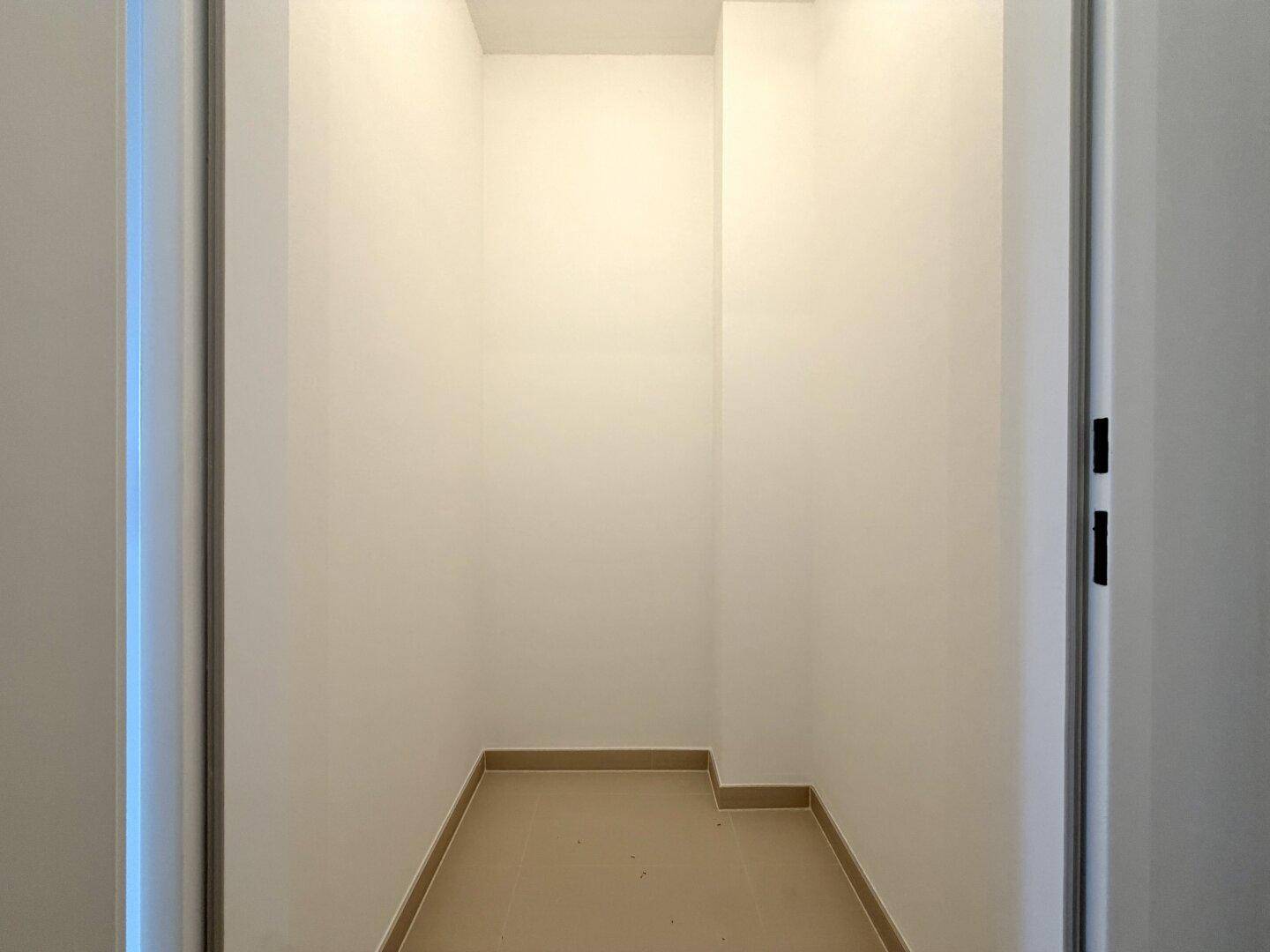 Praktischer Abstellraum mit Fliesenboden und weißen Wänden, ideal für zusätzlichen Stauraum.