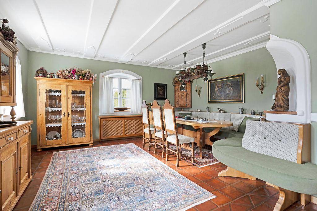 Rustikaler Essbereich mit Holztisch, traditionellen Möbeln und Blick ins Grüne.