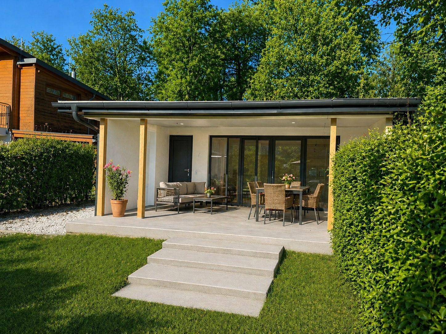 Moderne Terrasse mit bequemen Gartenmöbeln und direktem Zugang zum gepflegten Rasenbereich.