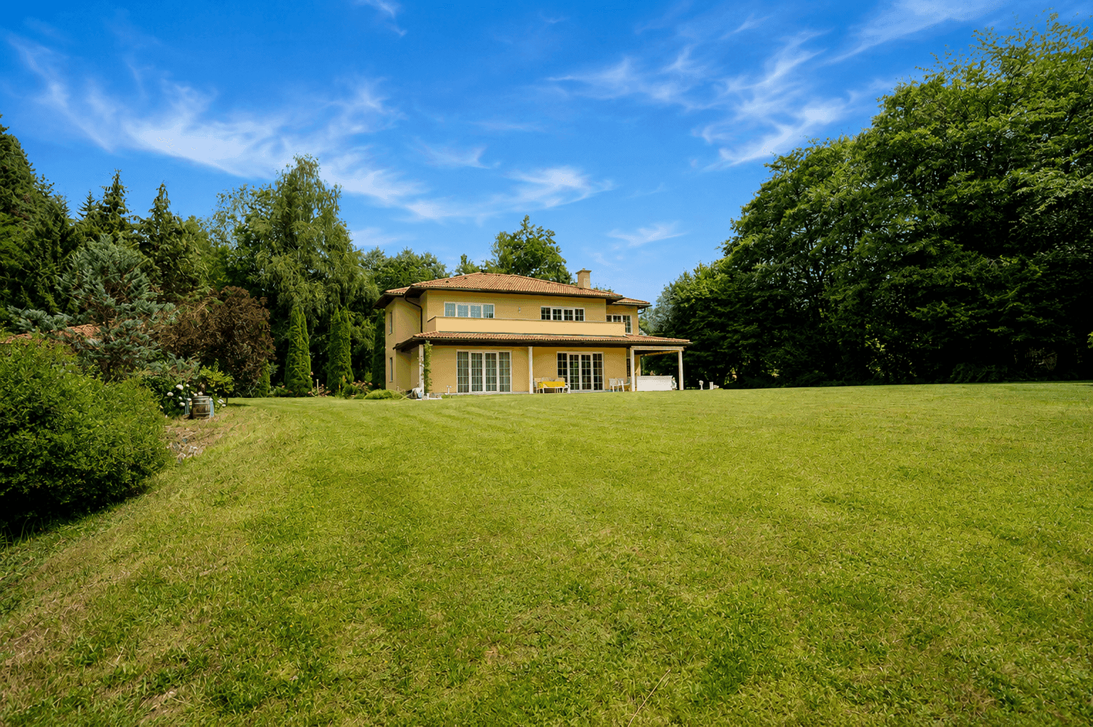 Das Einfamilienhaus liegt eingebettet in einen weitläufigen, grünen Garten mit altem Baumbestand.