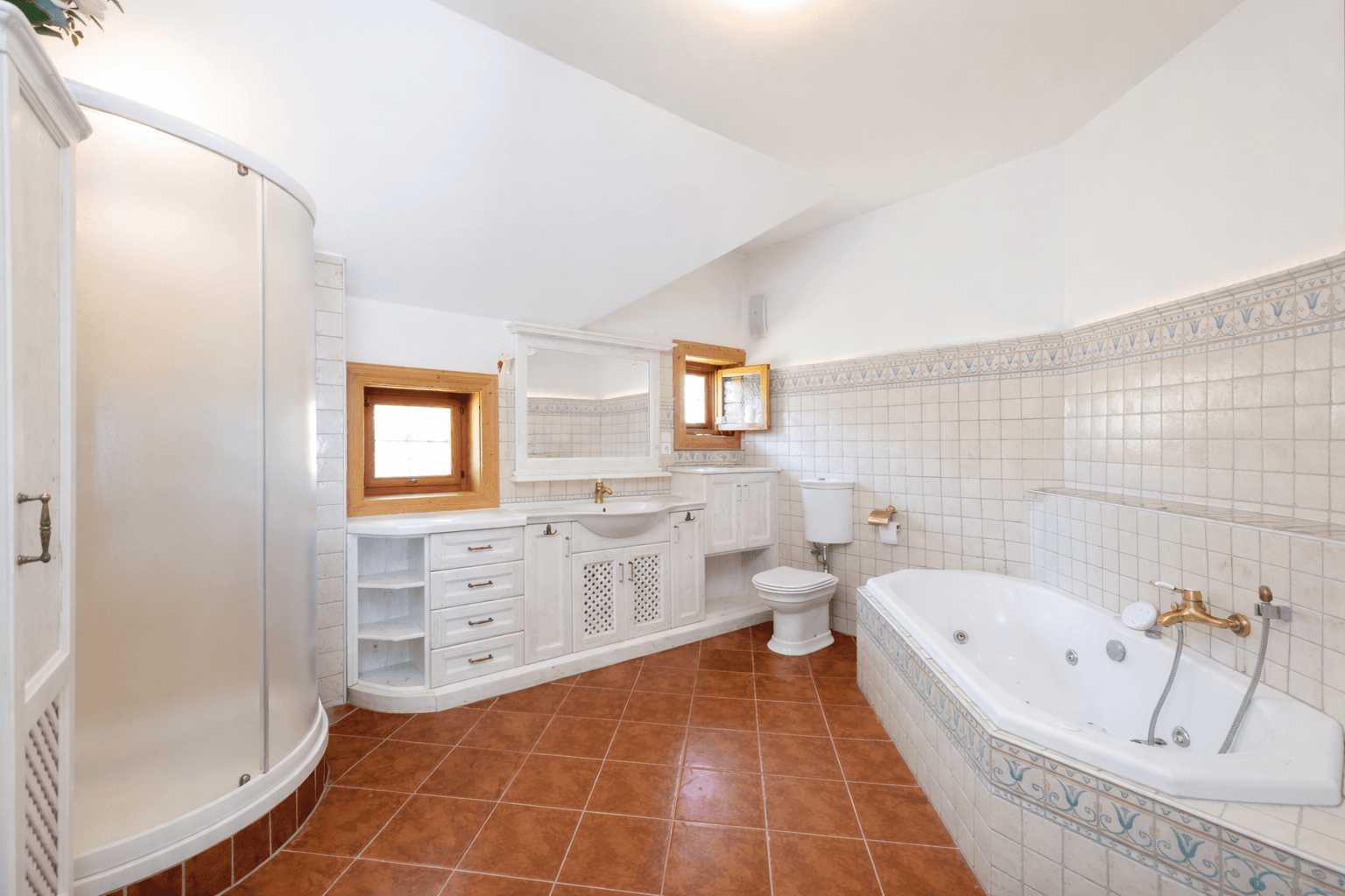 Geräumiges Badezimmer mit Eckbadewanne, Dusche, Doppelwaschbecken und traditionellen Fliesen.