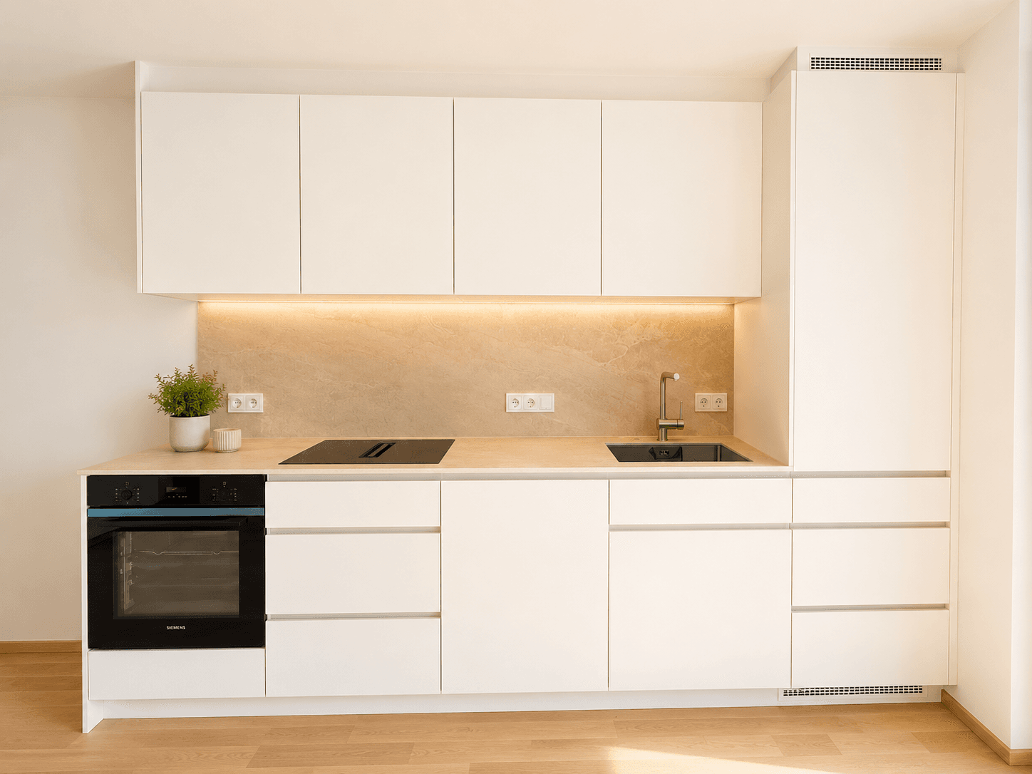Moderne Einbauküche in Weiß mit integrierten Siemens-Geräten und heller Holzoptik-Arbeitsplatte.