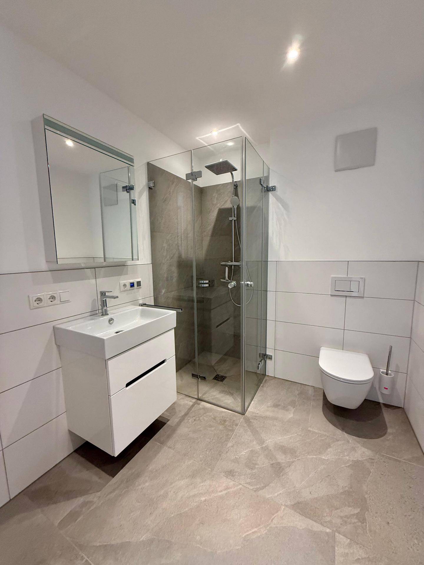 Modernes Badezimmer mit begehbarer Dusche, Wand-WC und schwebendem Waschtisch.