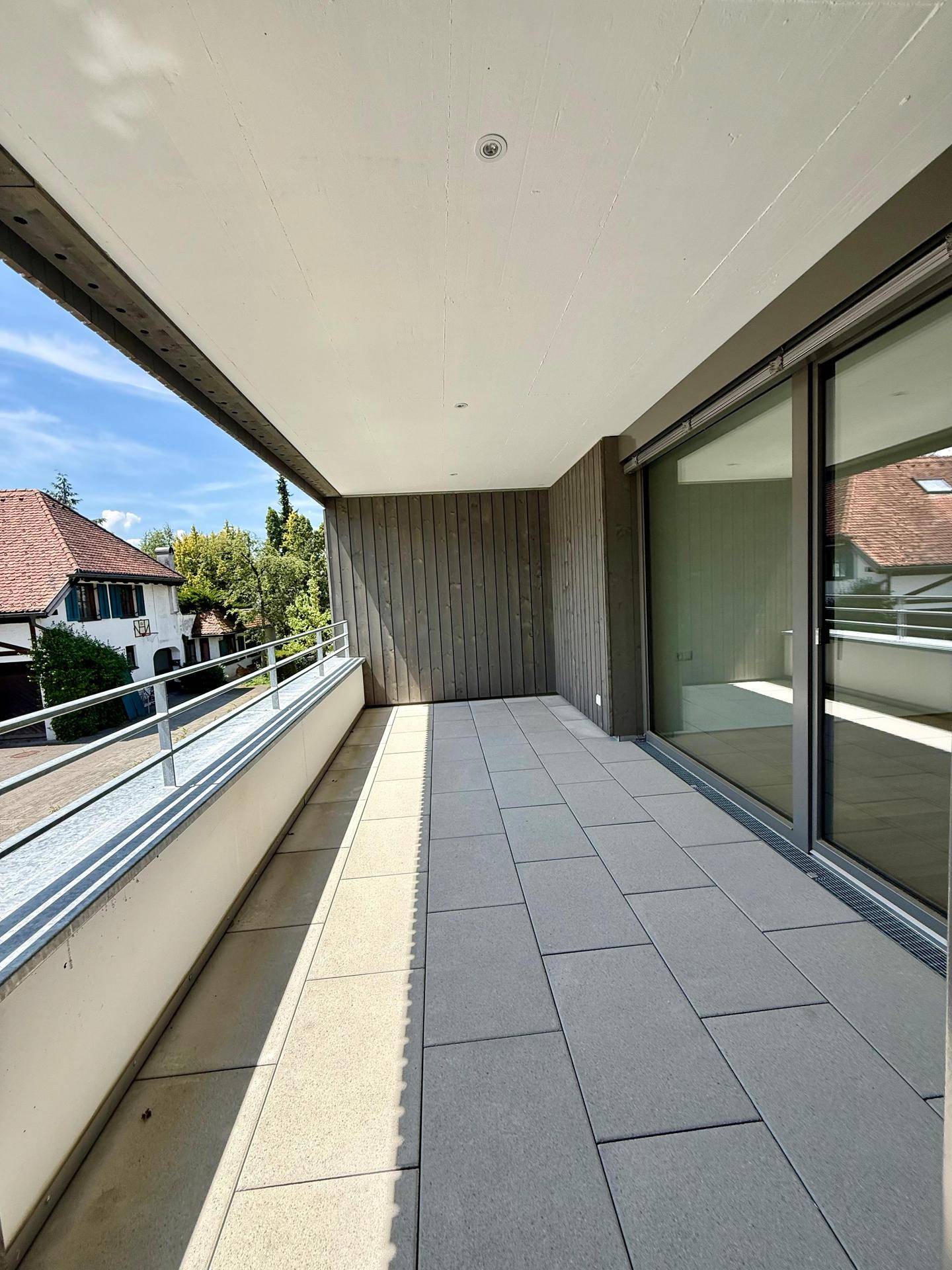Geräumiger Balkon mit Fliesenboden und Blick auf die umliegende Wohngegend.