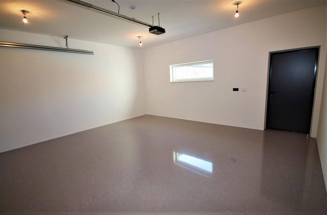 Geräumige Garage mit glänzendem Boden und einem Fenster für Tageslicht.