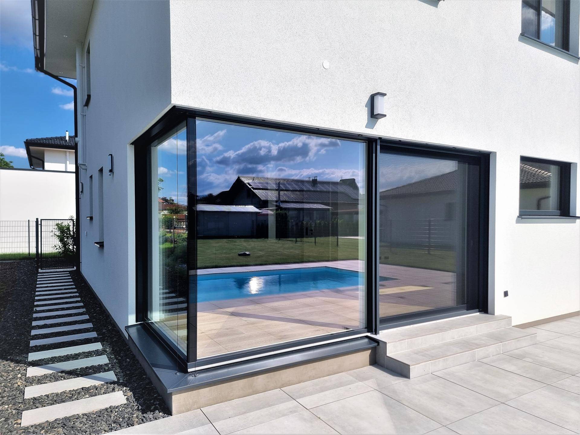 Große Glasfronten und Schiebetüren öffnen das moderne Haus zum Poolbereich und zur Terrasse.