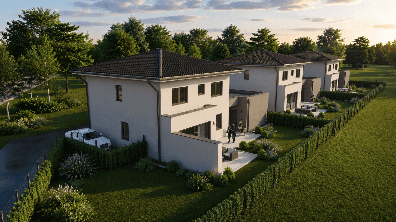 Ansicht einer modernen Reihenhaussiedlung mit Gärten, Terrassen und Carports bei Sonnenuntergang.