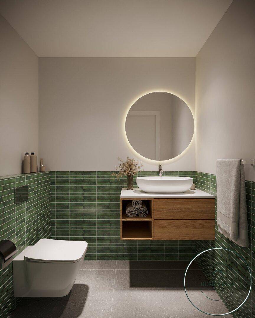 Modernes Badezimmer mit grünen Fliesen, rundem beleuchtetem Spiegel und schwebendem Waschtischunterschrank.