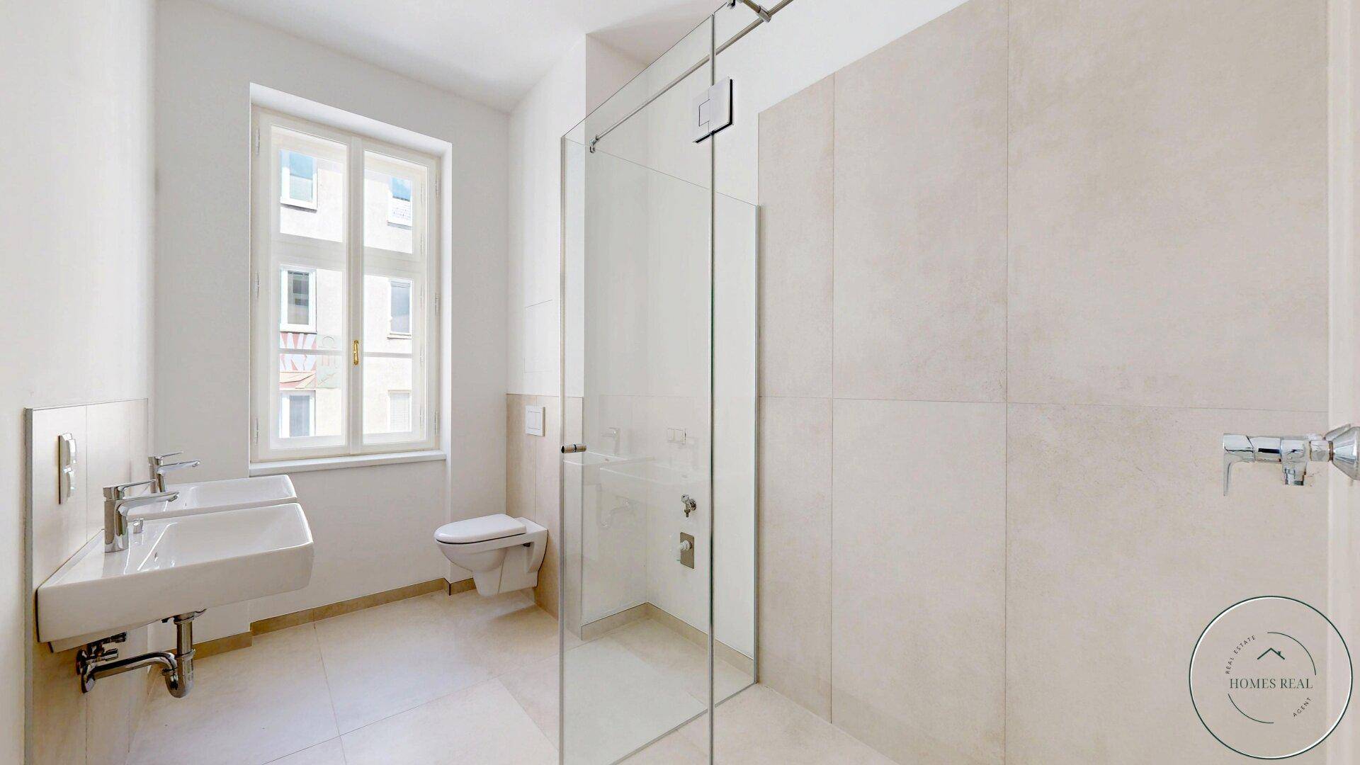 Modernes Badezimmer mit ebenerdiger Dusche, Wand-WC und Fenster für Tageslicht.