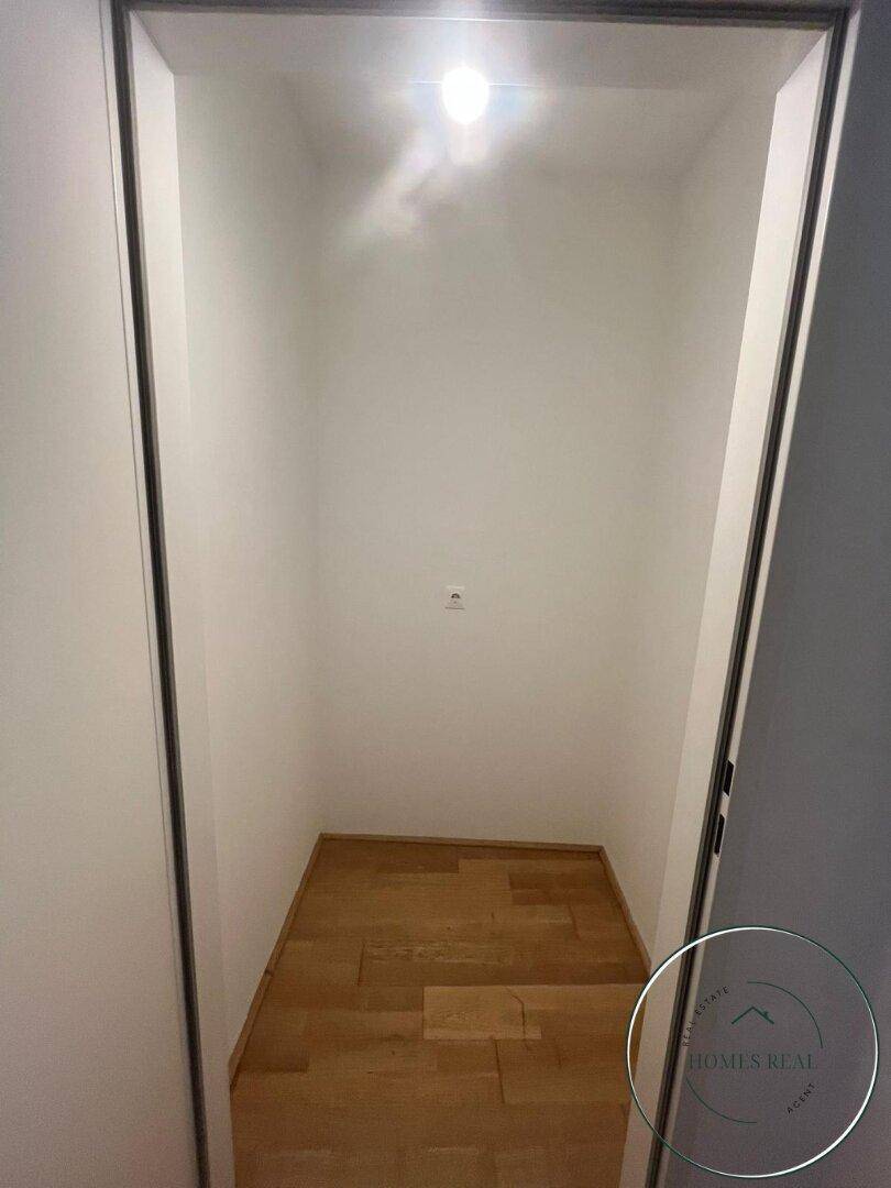 Praktischer Abstellraum mit Holzboden und Beleuchtung, bietet zusätzlichen Stauraum für Haushaltsgegenstände.