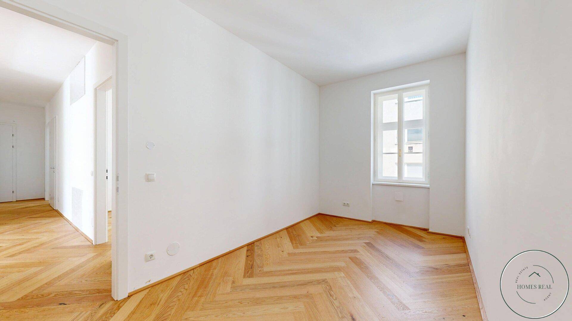 Heller Raum mit Fischgrätparkett und weiß gestrichenen Wänden, bereit zur individuellen Gestaltung.