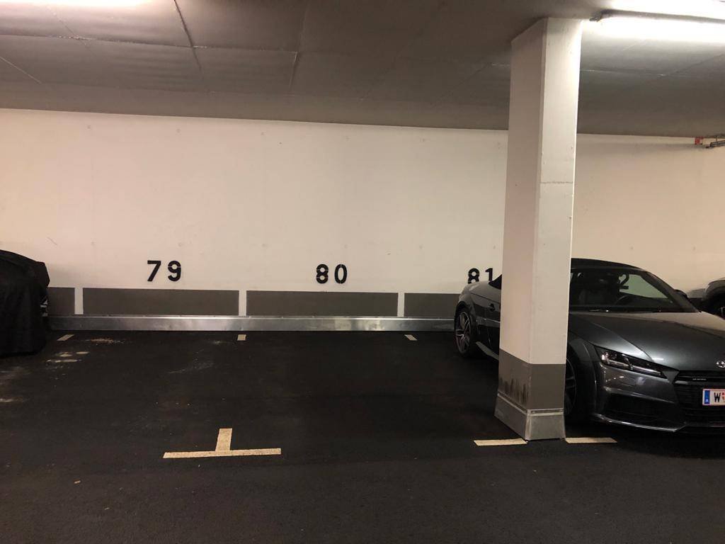 Tiefgarage mit nummerierten Stellplätzen und einem geparkten Fahrzeug.