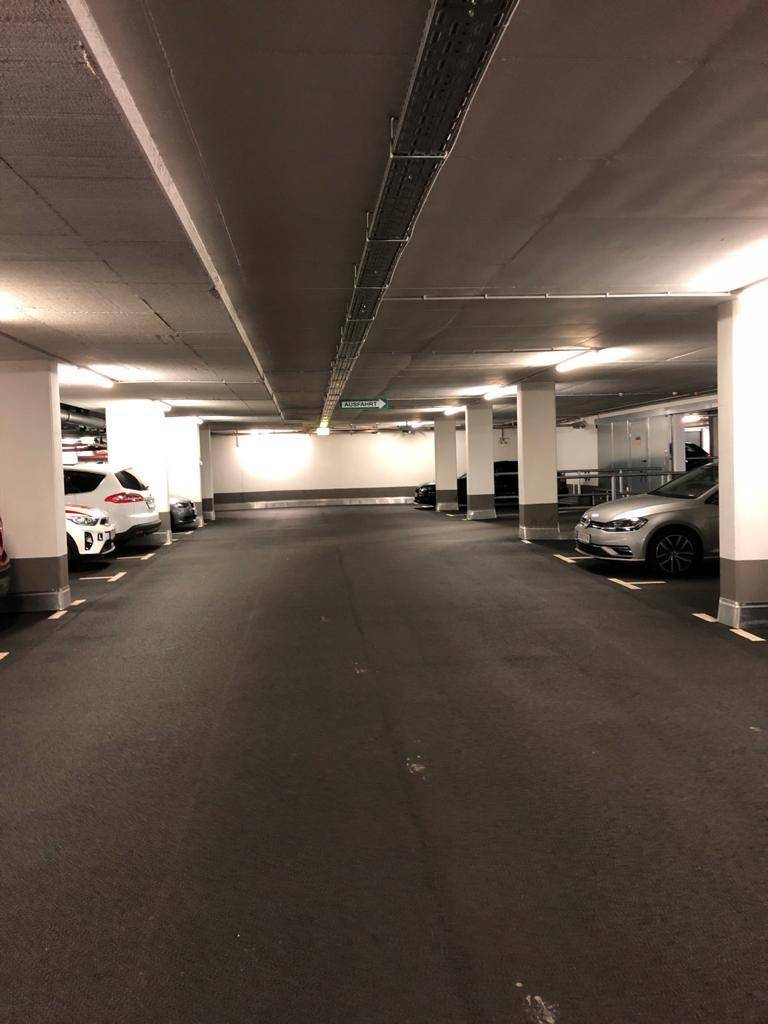 Geräumige Tiefgarage mit vielen Stellplätzen, Säulen und guter Beleuchtung.