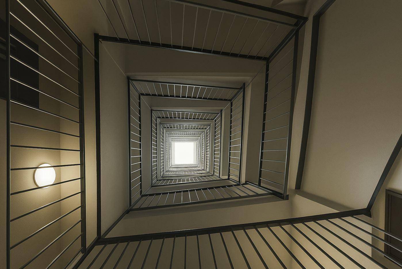 Architektonisch interessante Treppe mit Metallgeländer, die sich nach oben windet.