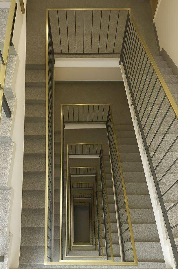 Blick von oben auf eine moderne Treppe mit Metallgeländer und Granitstufen.
