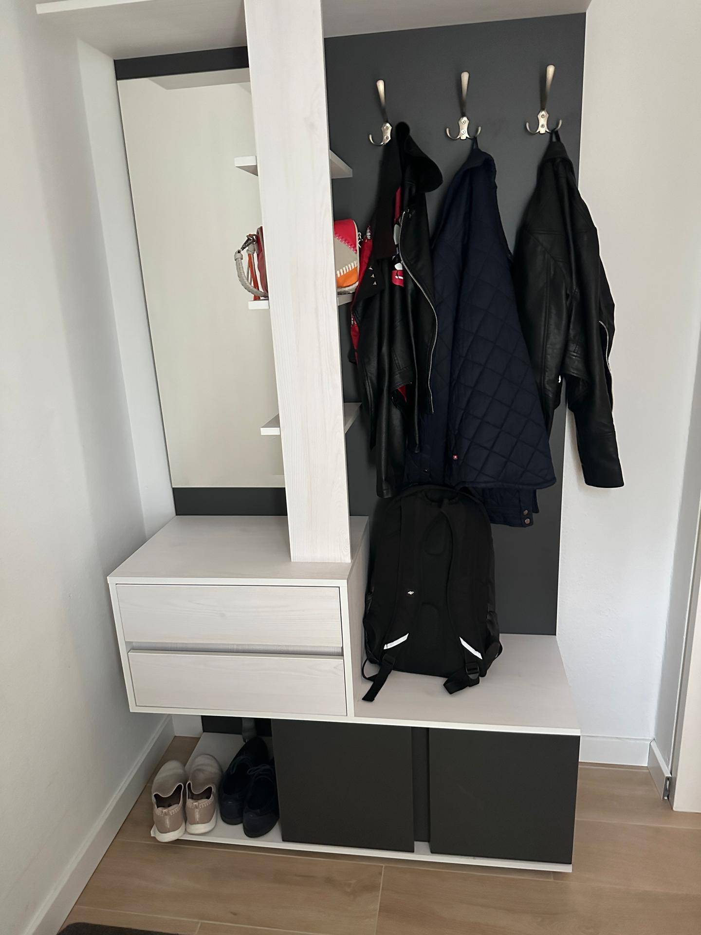 Moderner Eingangsbereich mit Garderobe, Spiegel und praktischen Schuhschränken.