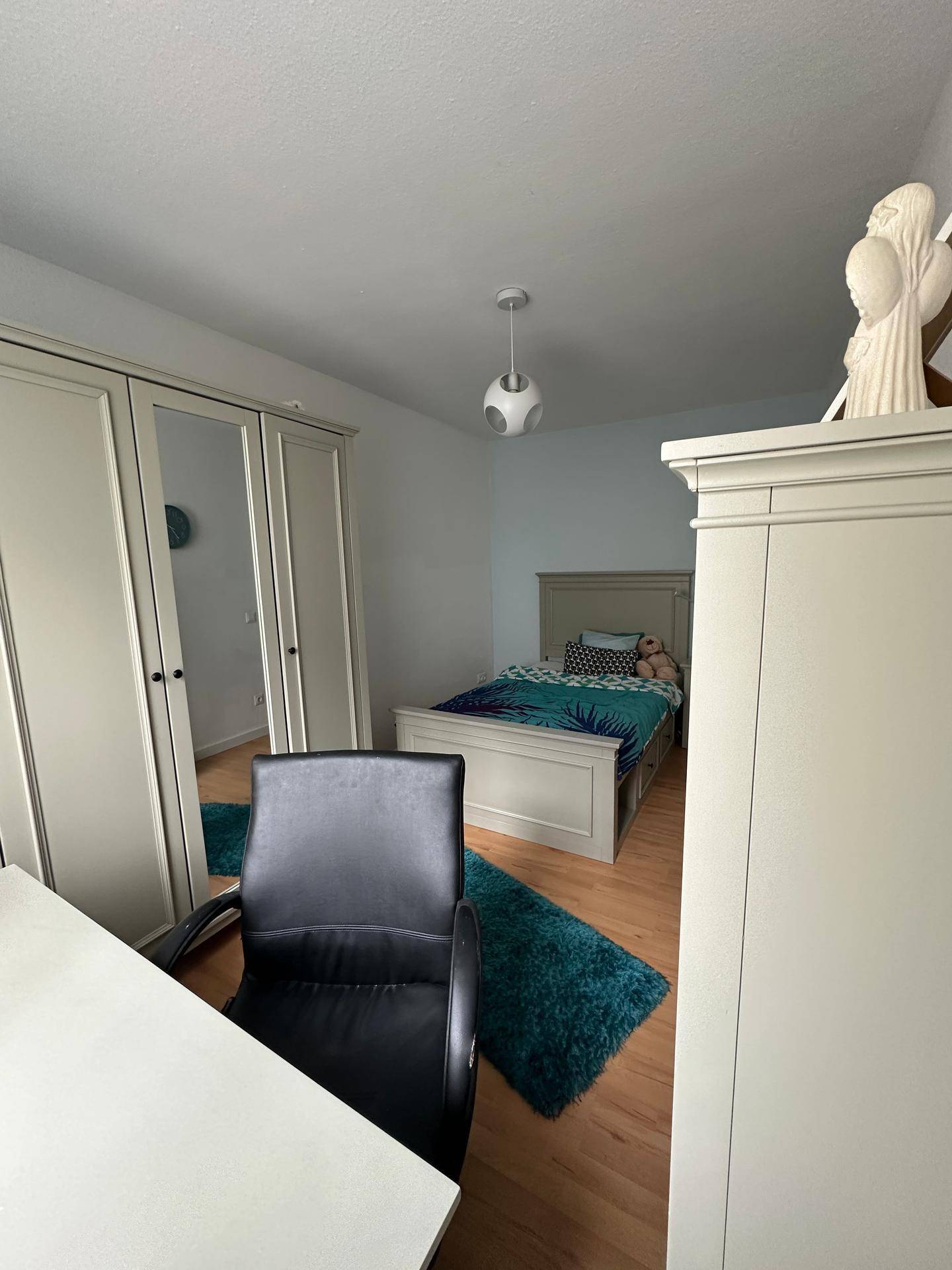Kinderzimmer mit Bett, Schreibtisch und Kleiderschrank, funktional und freundlich gestaltet.