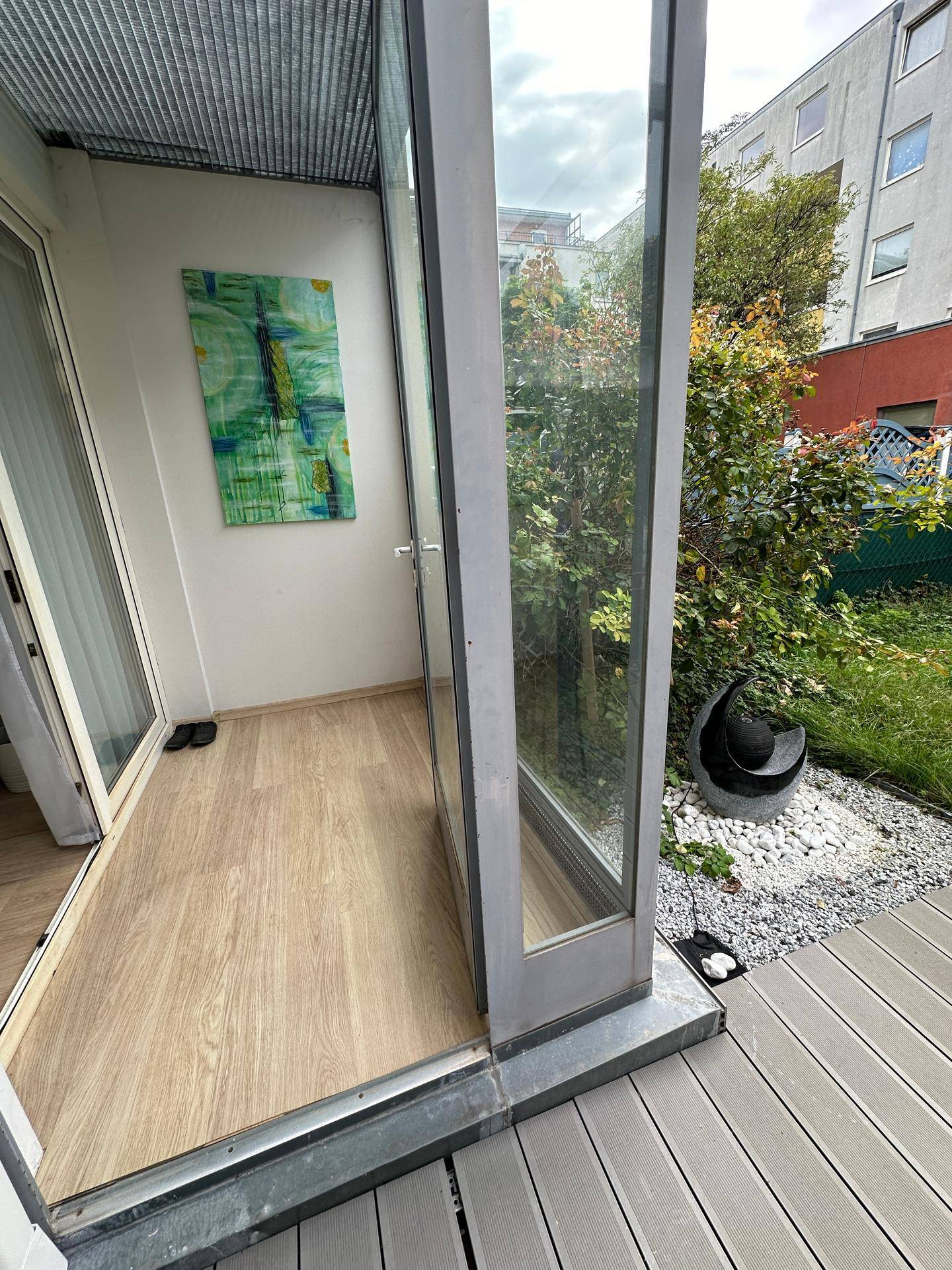 Heller Terrassenzugang mit Holzboden und Blick auf den Gartenbereich und die Umgebung.