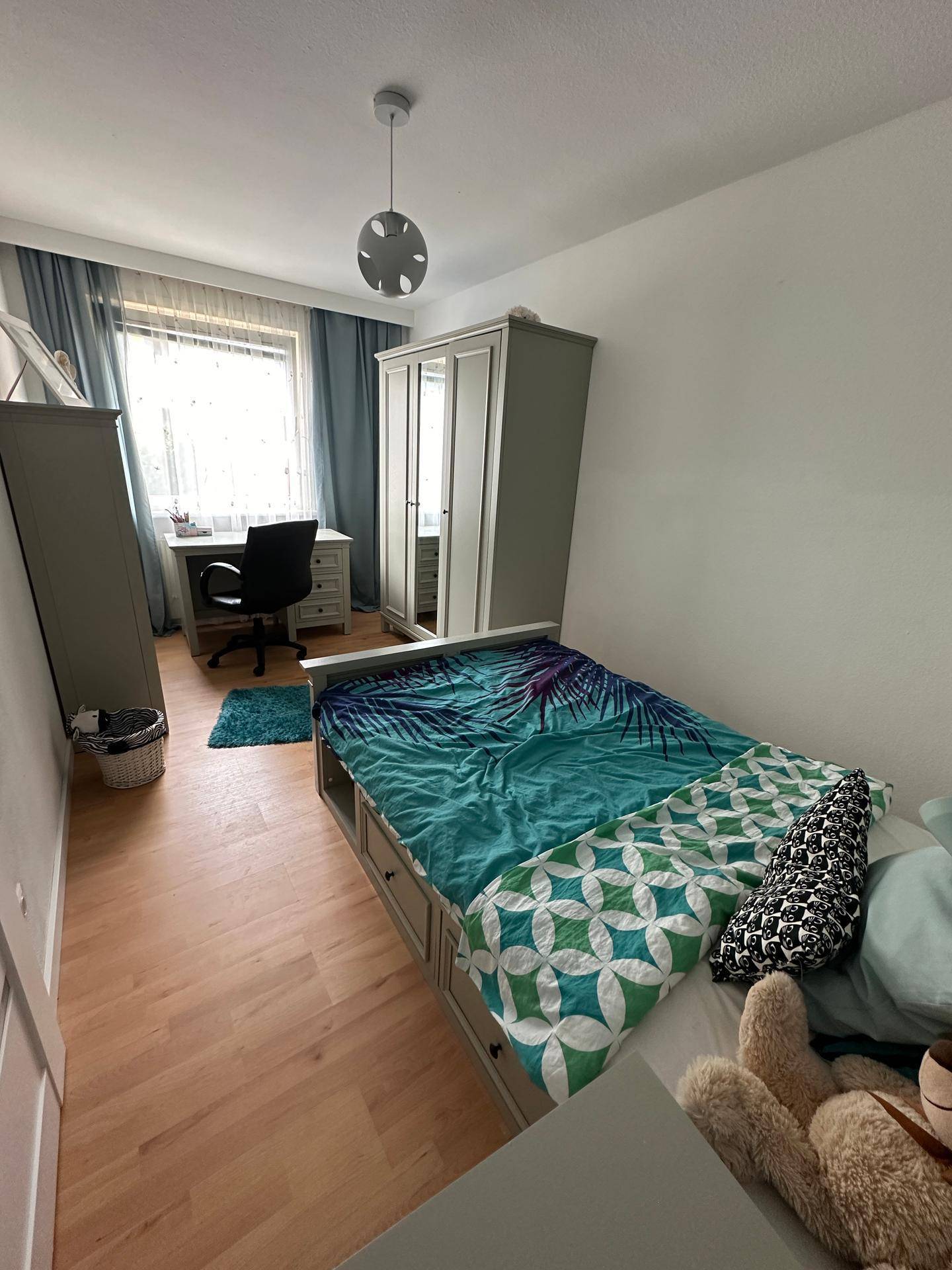 Kinderzimmer mit Einzelbett, Schreibtisch und Kleiderschrank, hell und funktional eingerichtet.
