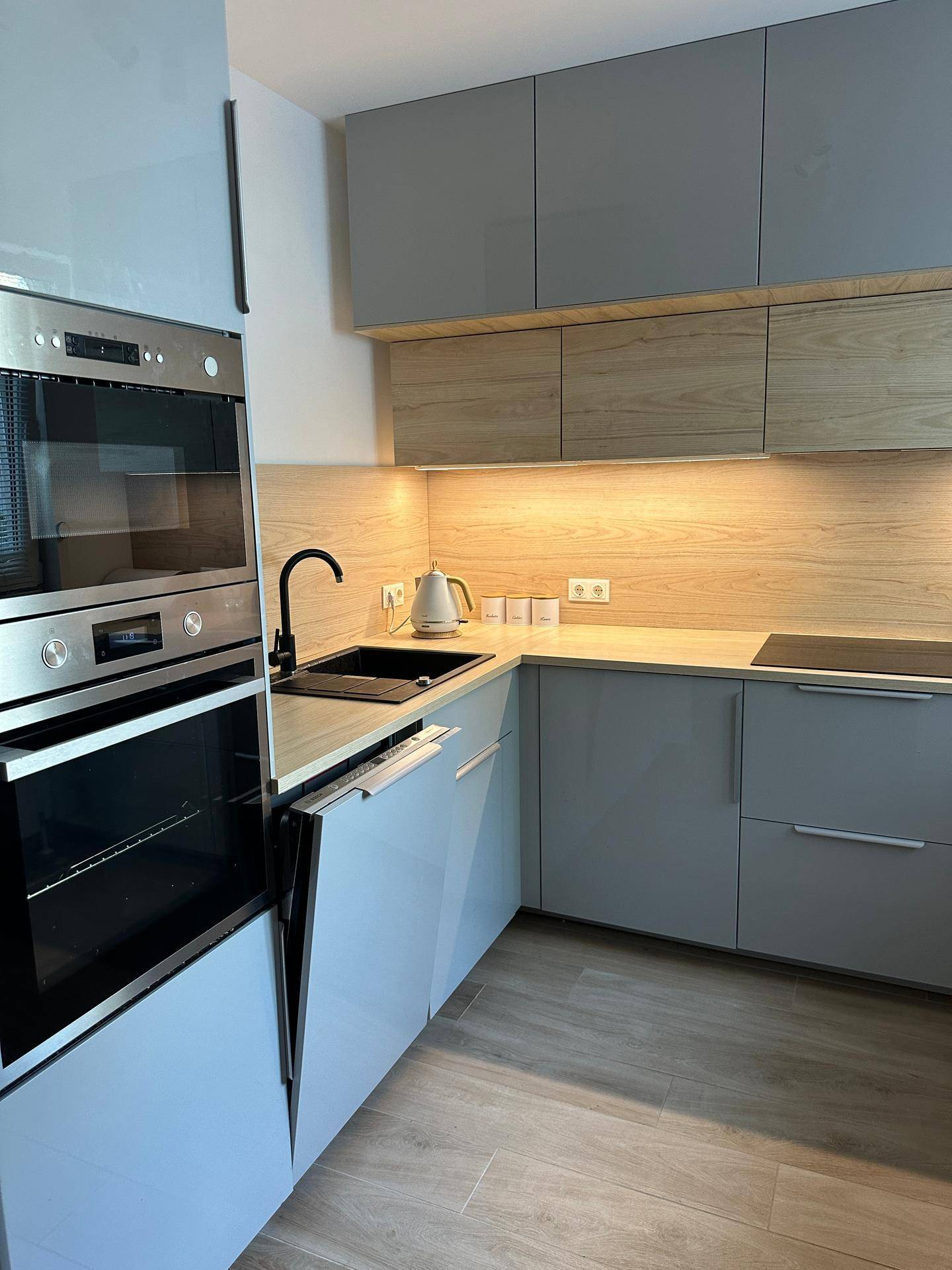 Stilvolle Küche mit integriertem Geschirrspüler, Backofen und moderner Spüle.