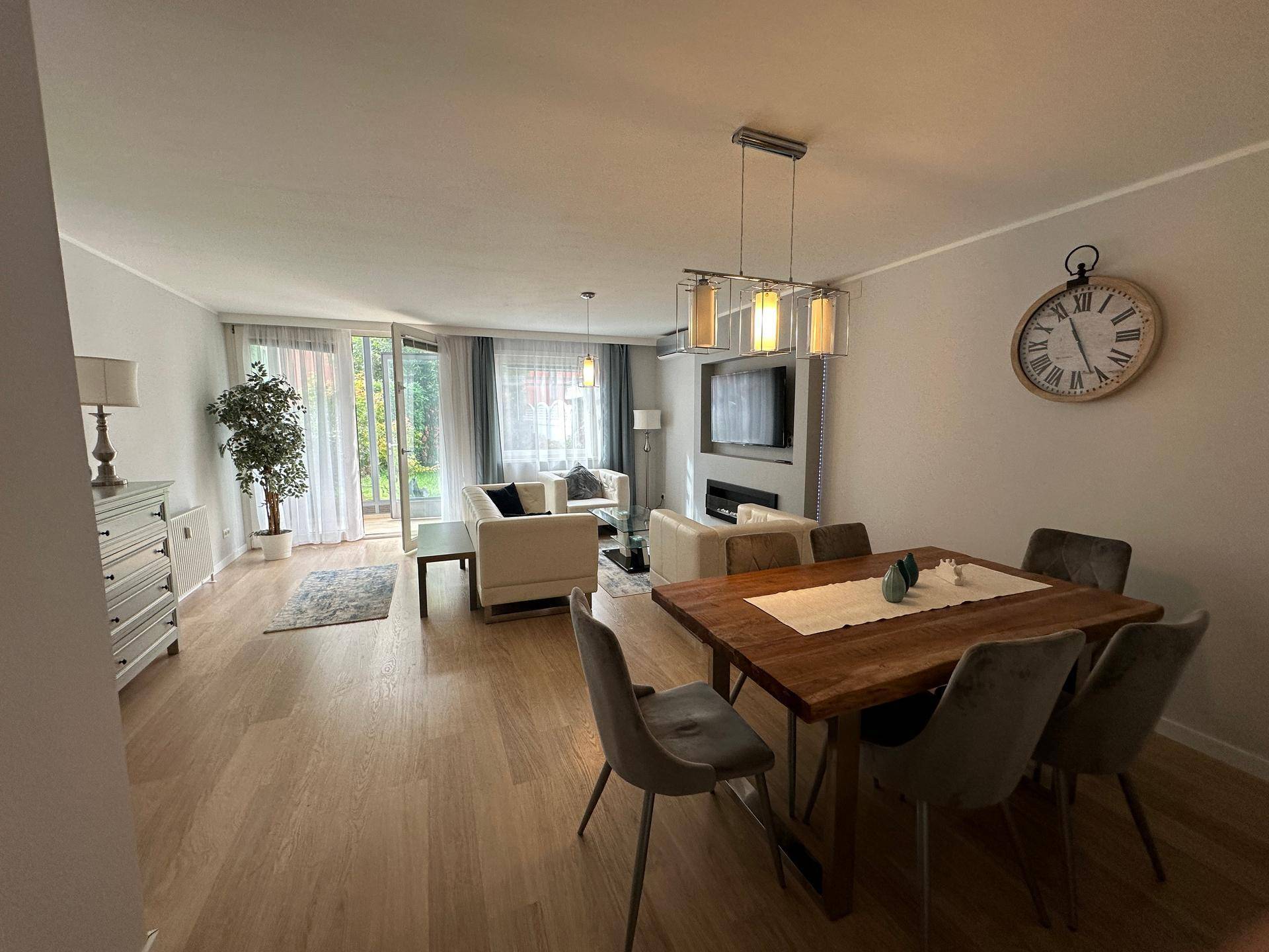 Heller Wohn- und Essbereich mit Zugang zur Terrasse und großem Esstisch für gesellige Runden.