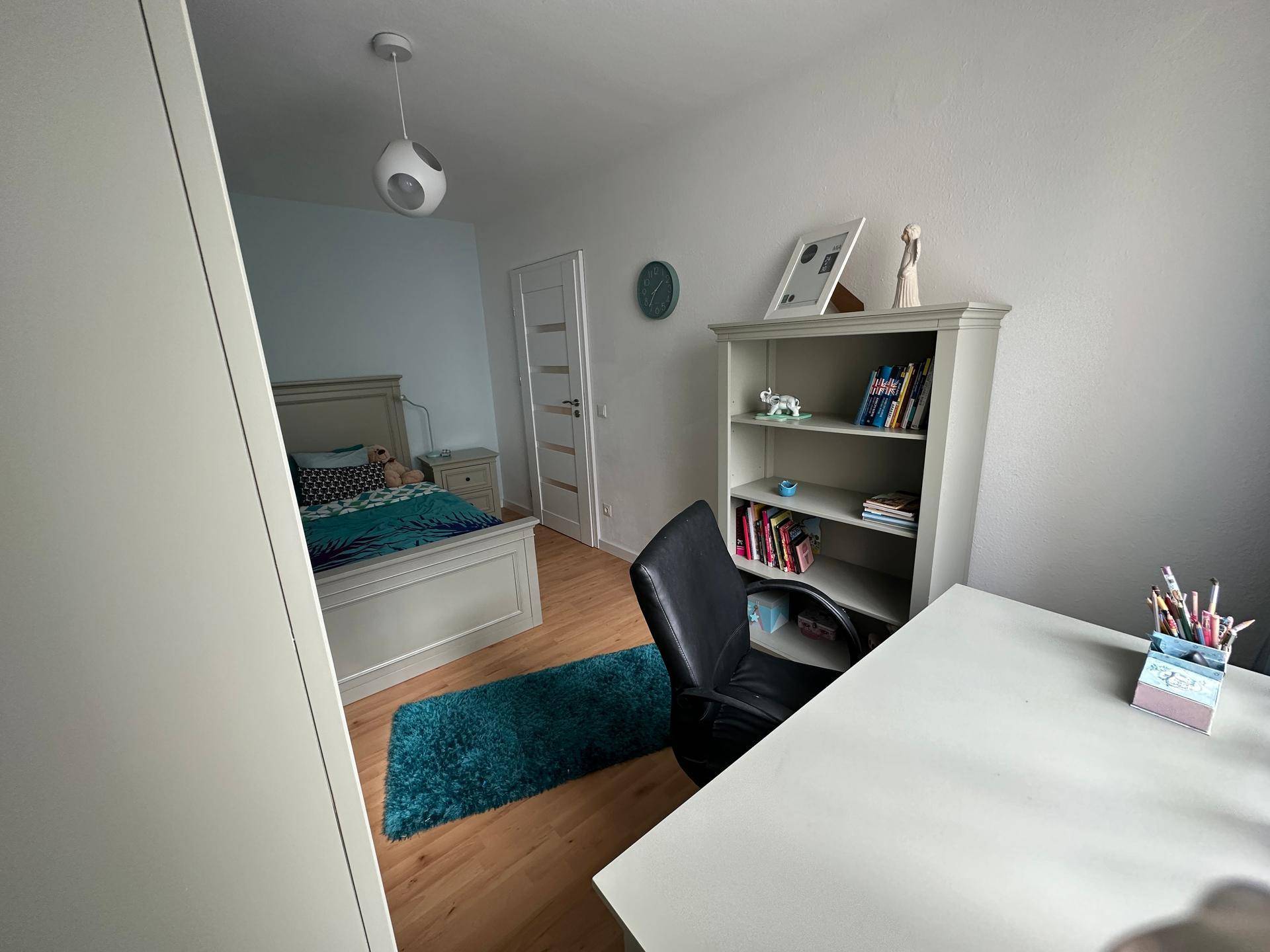 Helles Kinderzimmer mit Bett, Schreibtisch und Regal, ideal zum Lernen und Spielen.
