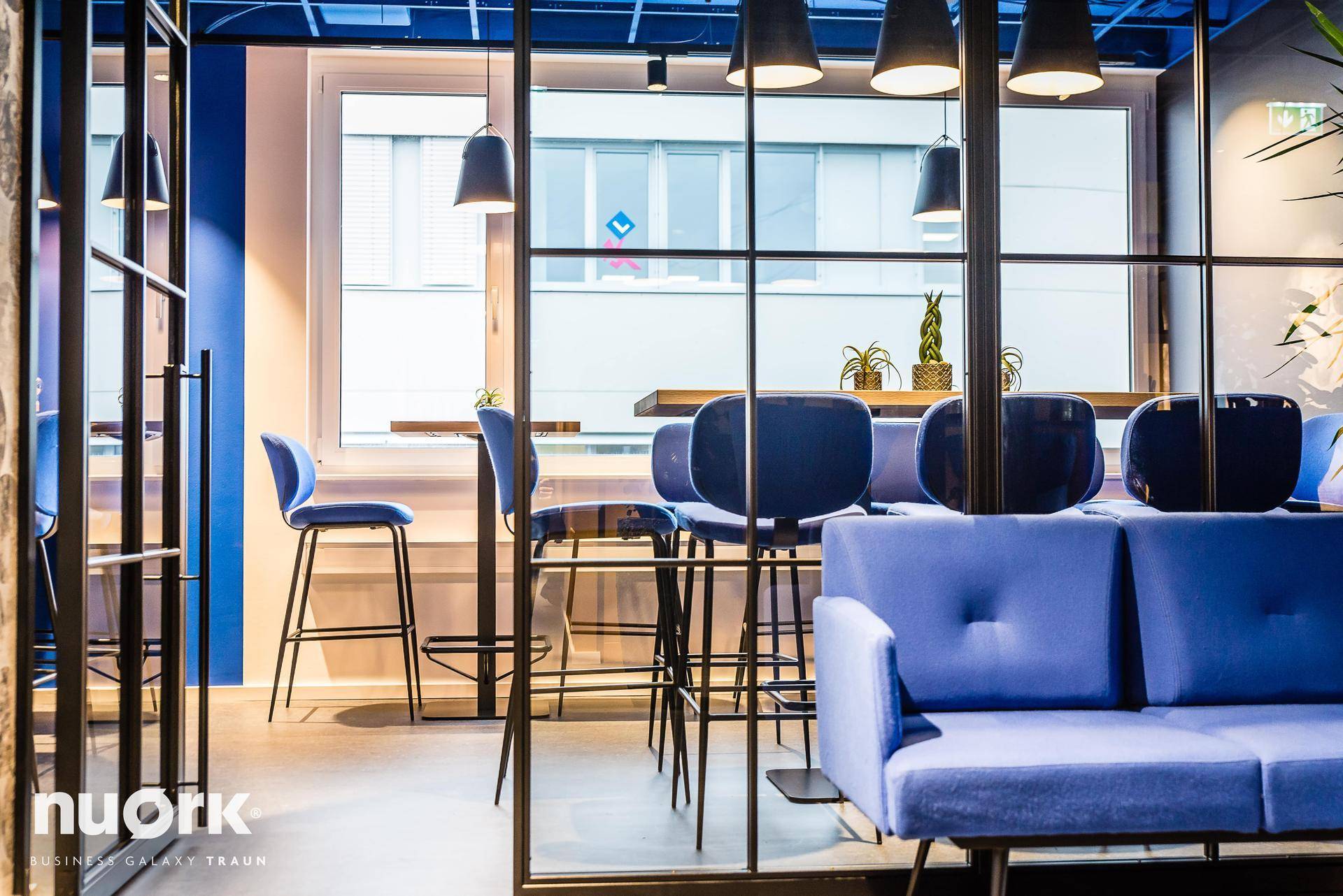Moderner Lounge-Bereich mit dekorativem Regal, Pflanzen und kreativer Wandgestaltung.