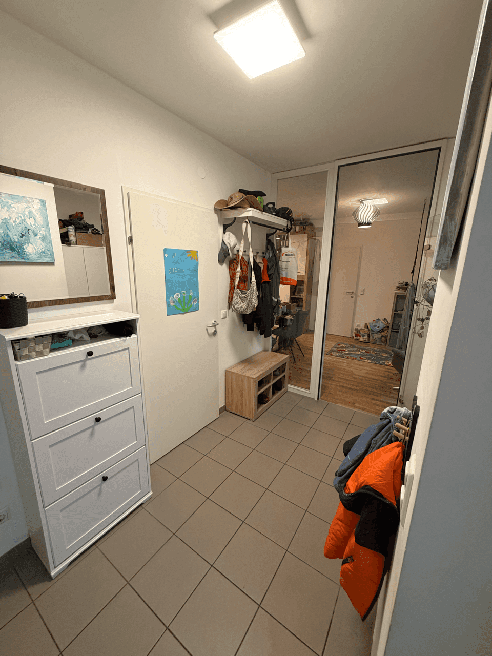 Eingangsbereich mit Fliesenboden, Schuhschrank und Garderobe, bietet praktischen Stauraum.