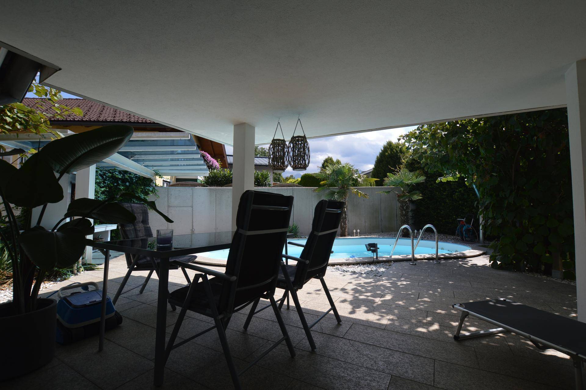 Überdachte Terrasse mit Essbereich und Blick auf den privaten Swimmingpool.