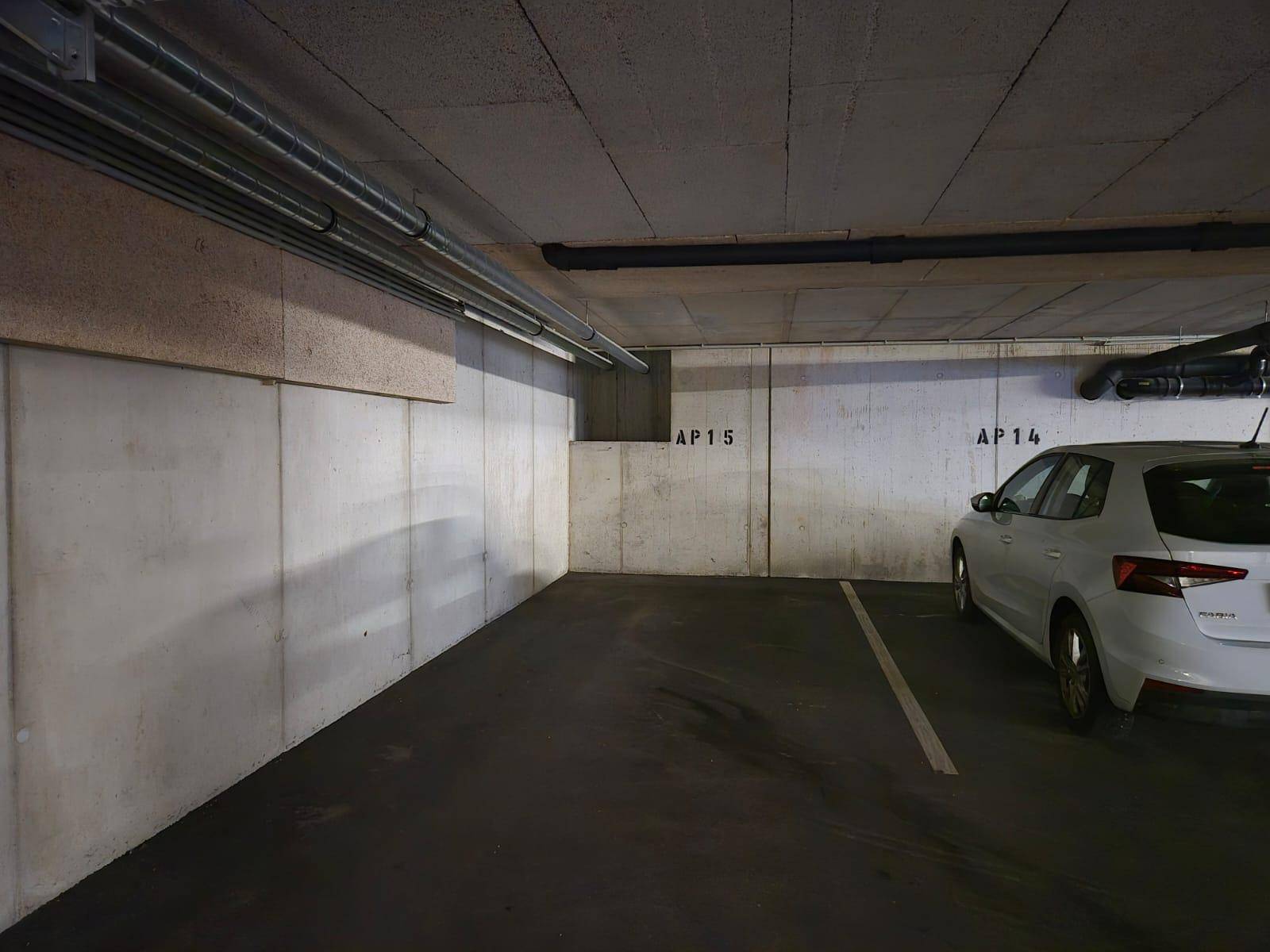 Saubere Tiefgarage mit Betonwänden und markierten Stellplätzen für Fahrzeuge.