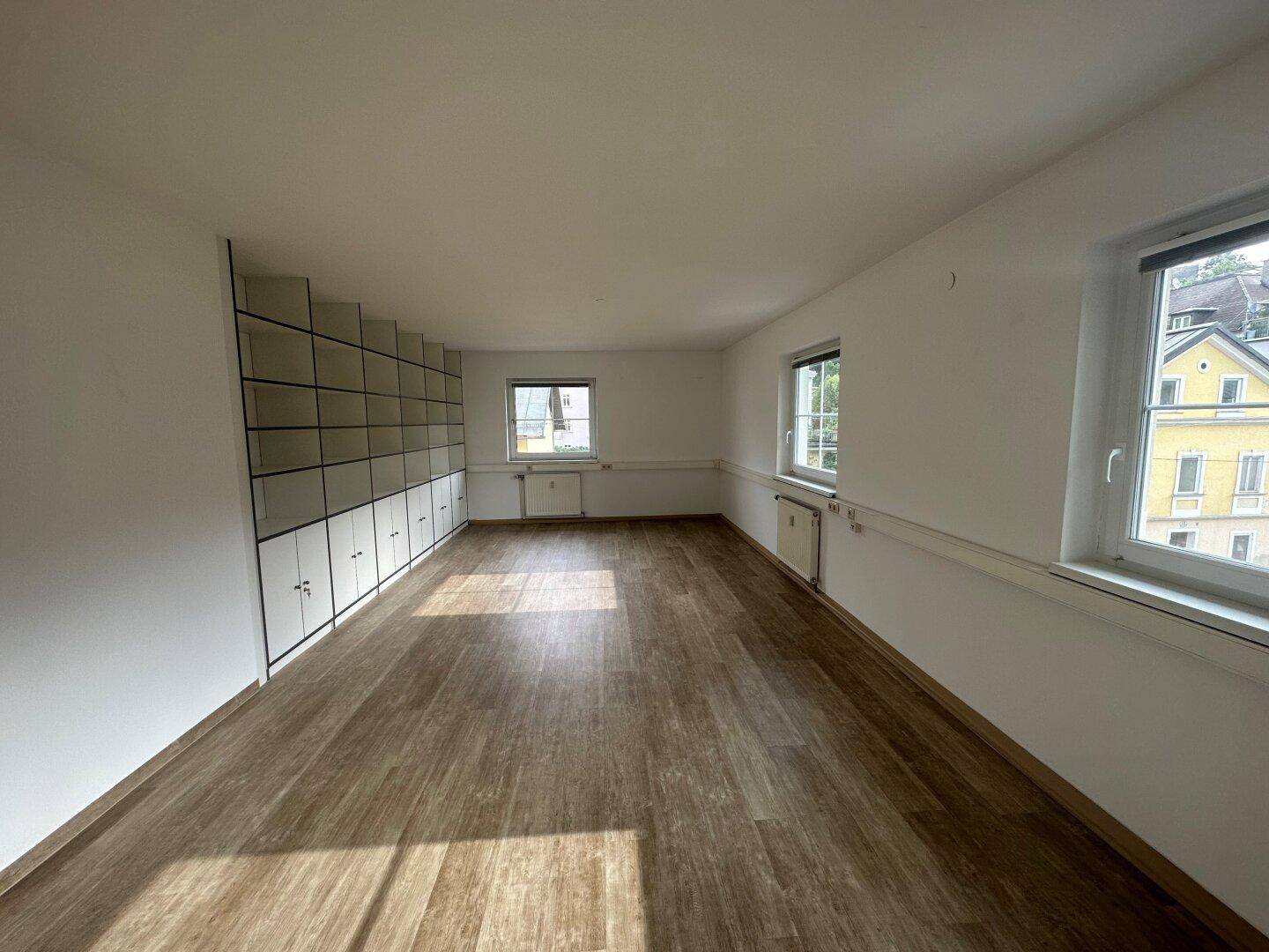 Geräumiger Büroraum mit vielen Fenstern, die viel Tageslicht hereinlassen und eine weite Aussicht bieten.