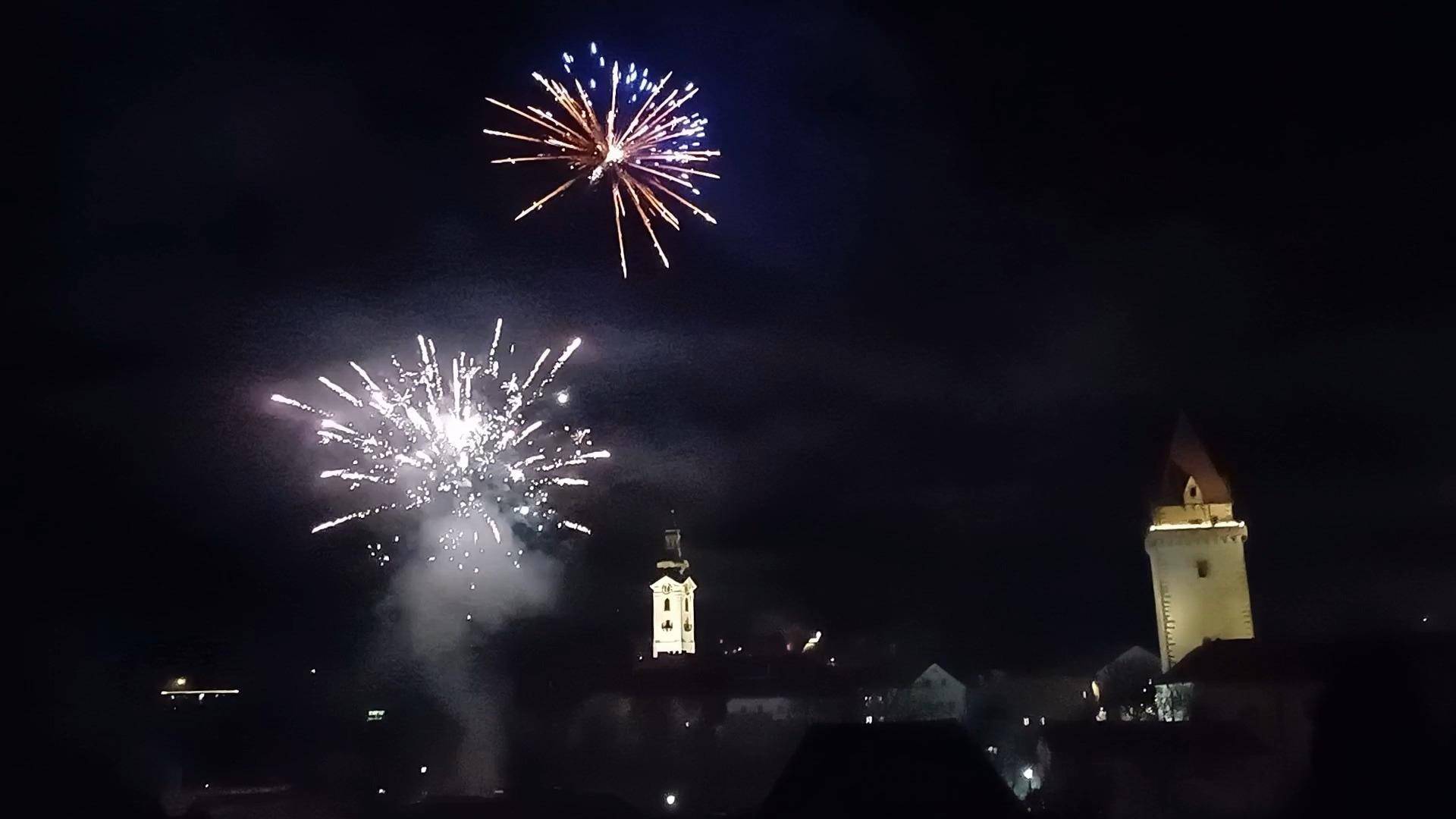 Feuerwerk über der beleuchteten Stadt mit ihren markanten Türmen in der Nacht.