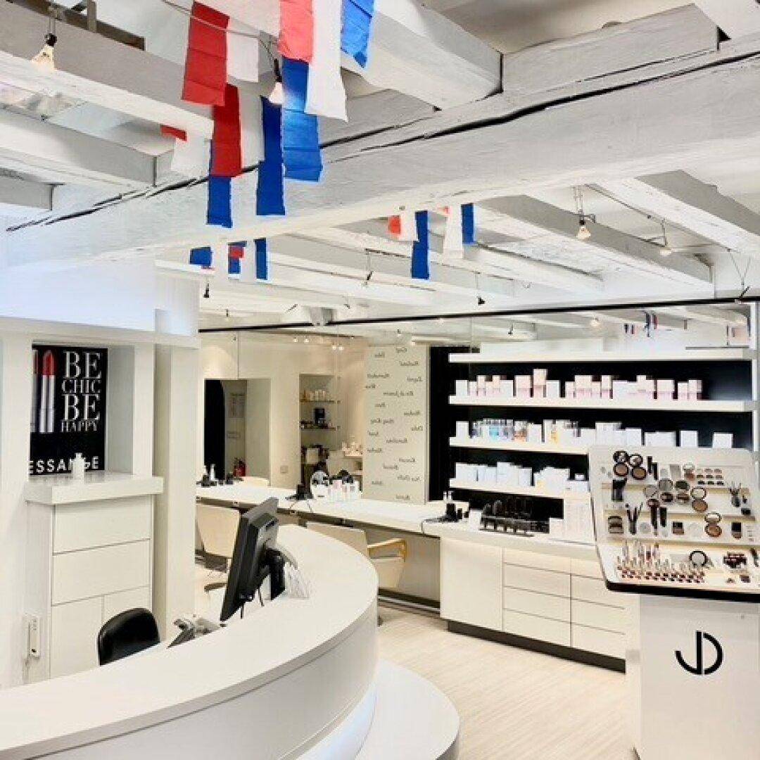 Moderner Empfangsbereich eines Salons mit sichtbaren Holzbalken und Produktpräsentation.