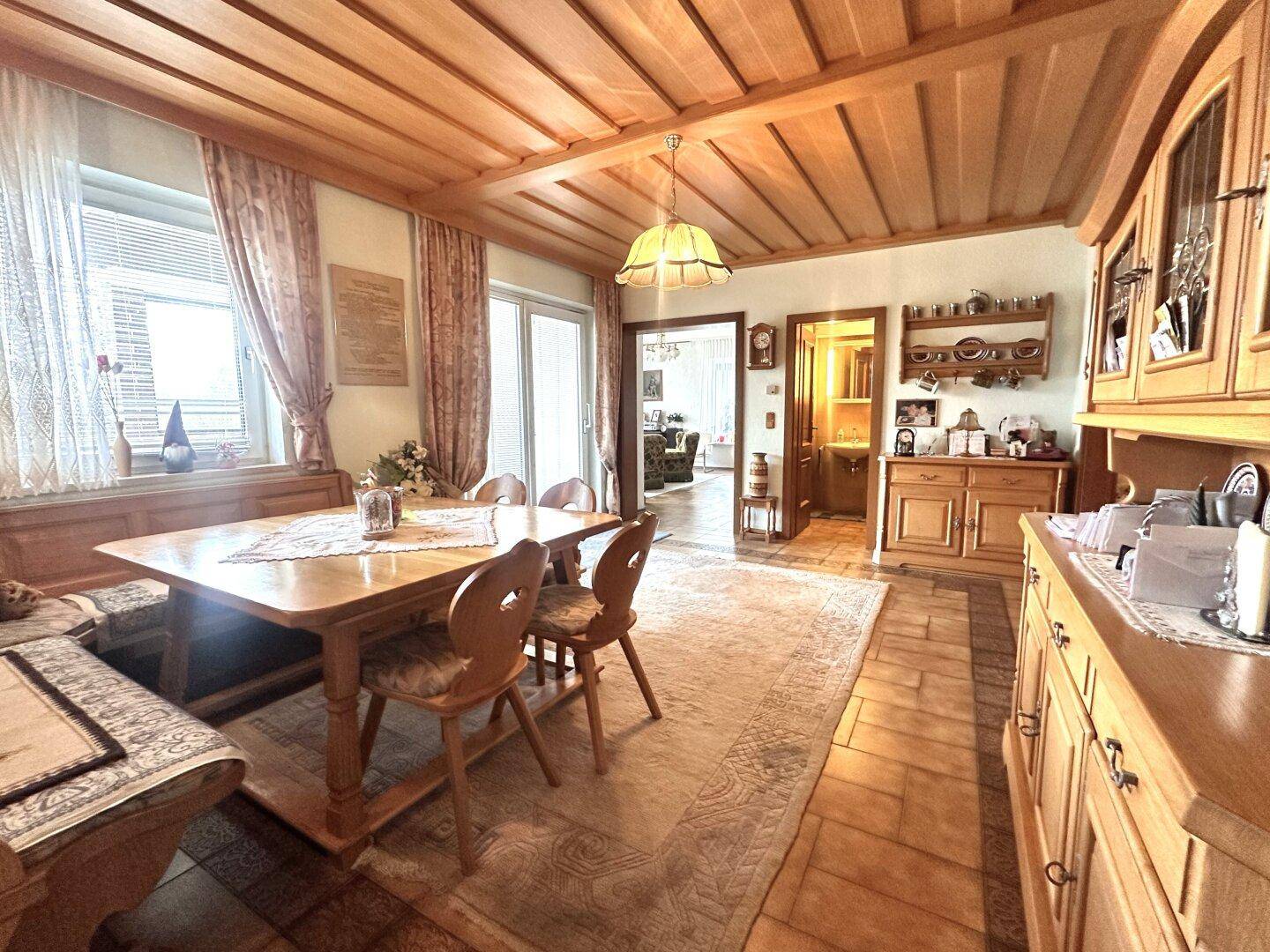 Gemütlicher Essbereich im traditionellen Stil mit Holztäfelung an Decke und Wänden sowie rustikalen Möbeln.