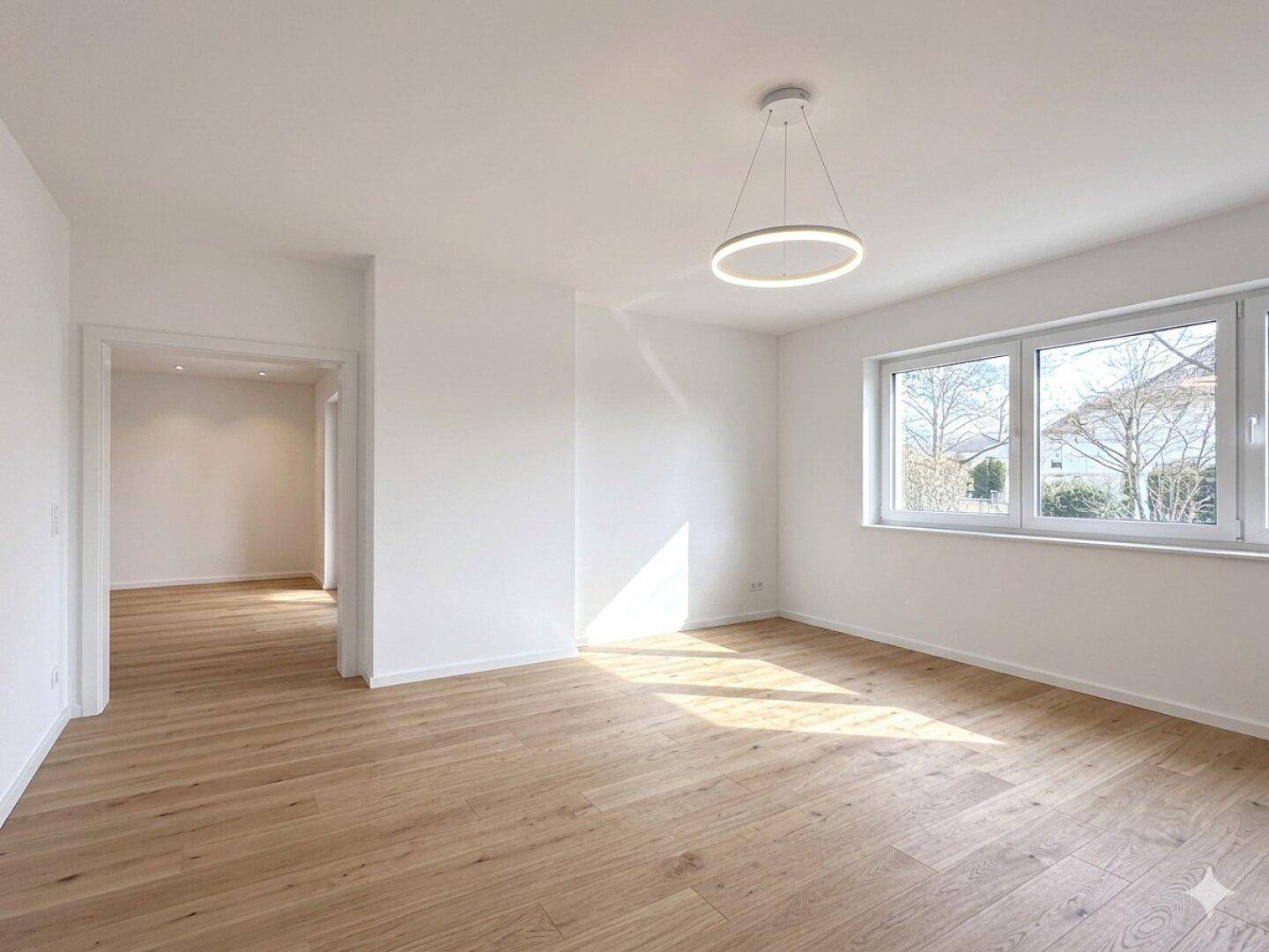 Lichtdurchflutetes Zimmer mit hellem Holzboden und großen Fenstern, ideal für ein modernes Wohnkonzept.