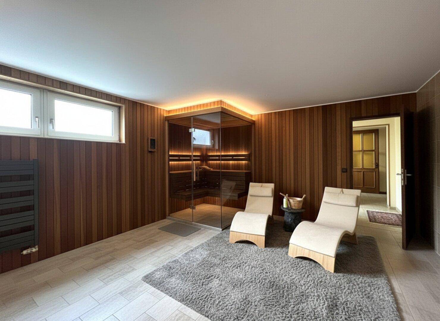 Moderner Wellnessbereich mit Sauna, Liegestühlen und Holzverkleidung für Entspannung.