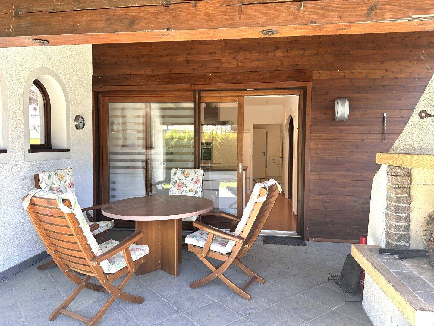 Gemütliche überdachte Terrasse mit Zugang zur Küche und einem gemauerten Grill für gesellige Abende.