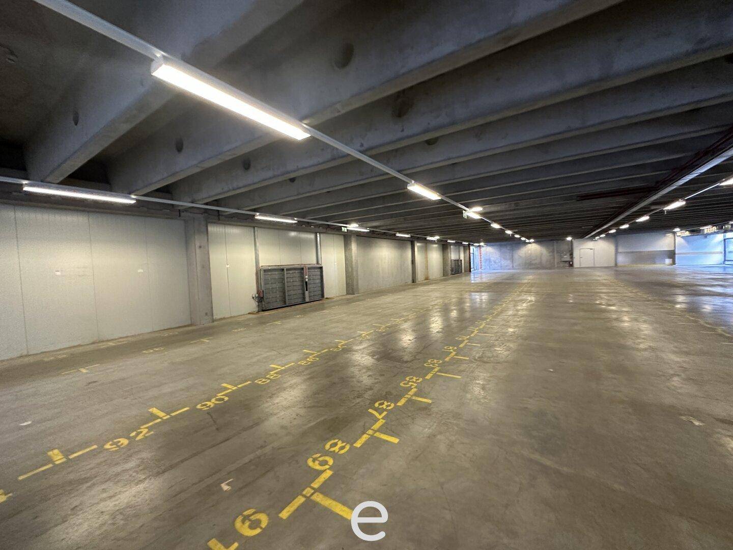 Geräumige Tiefgarage mit Betonboden und nummerierten Stellplätzen, bereit zur Nutzung.