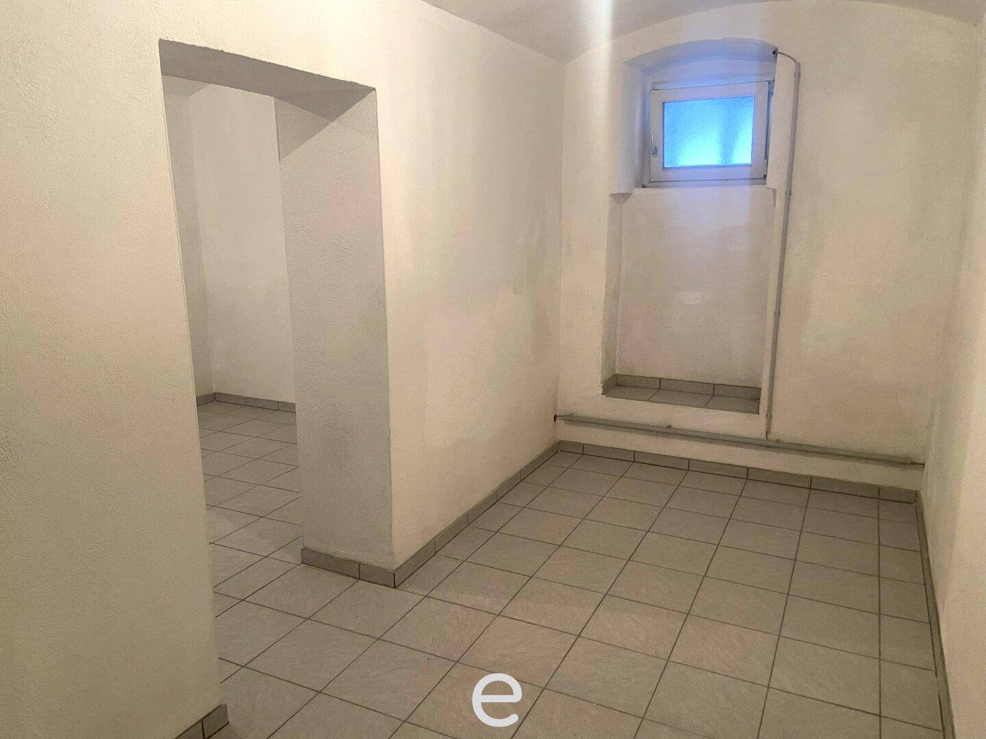 Funktionaler Kellerraum mit Fliesenboden und Tageslicht durch ein kleines Fenster.