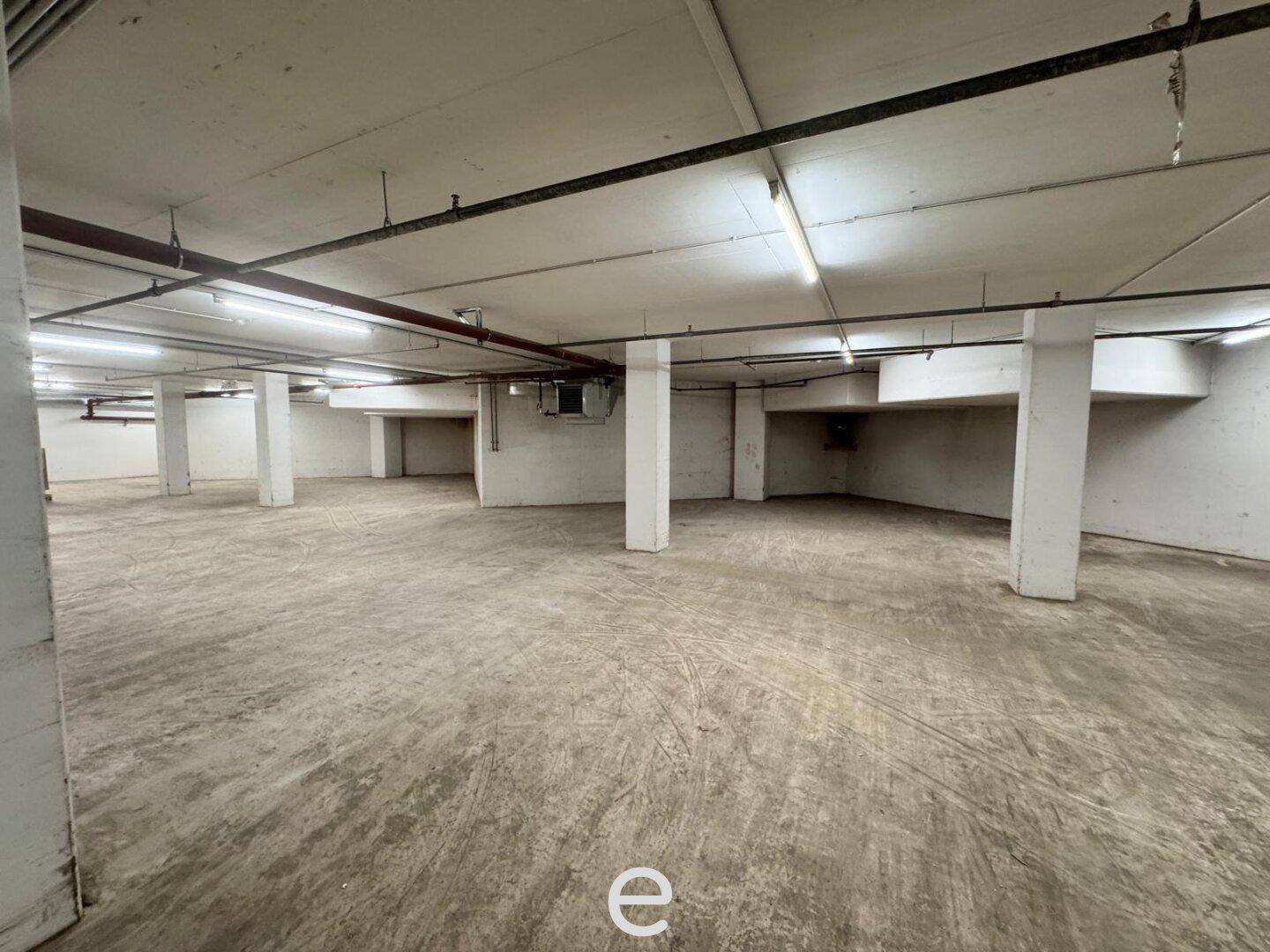 Geräumige Tiefgarage mit Betonboden und tragenden Säulen, ideal für Fahrzeugabstellung.