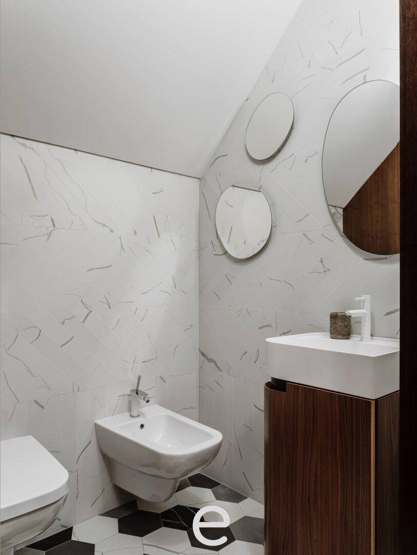 Modernes Badezimmer mit Marmorfliesen, Bidet und sechseckigem Bodenmuster, sehr stilvoll und hell.