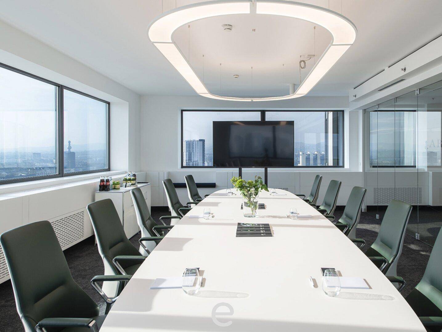 Heller Konferenzraum mit großem Tisch, bequemen Stühlen und Panoramablick auf die Stadt durch die Fenster.