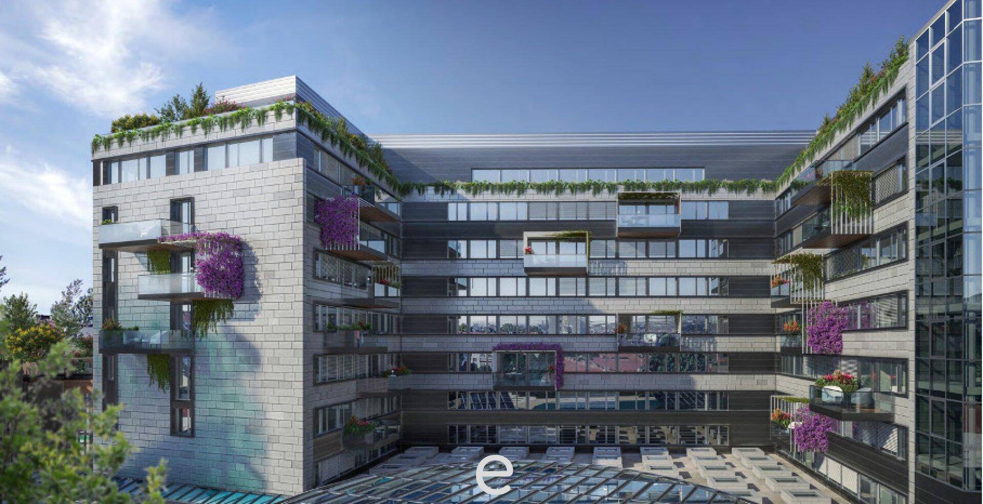Moderne Gebäudefassade mit vielen Fenstern, Balkonen und begrünten Dächern in urbaner Umgebung.